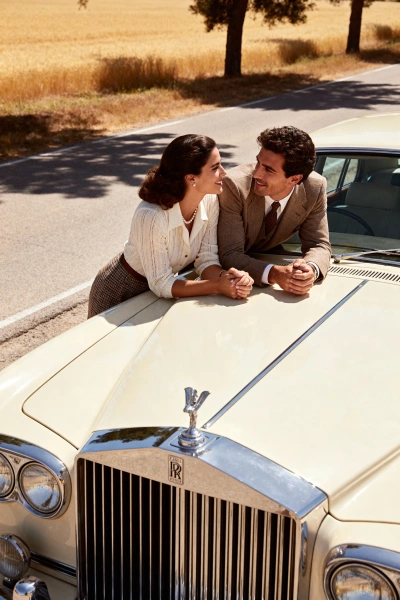Retro couple with a cream Rolls-Royce on a rural road