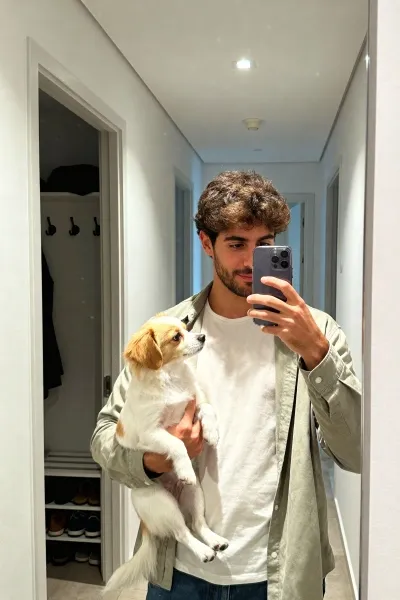 Man holding dog taking hallway mirror selfie
