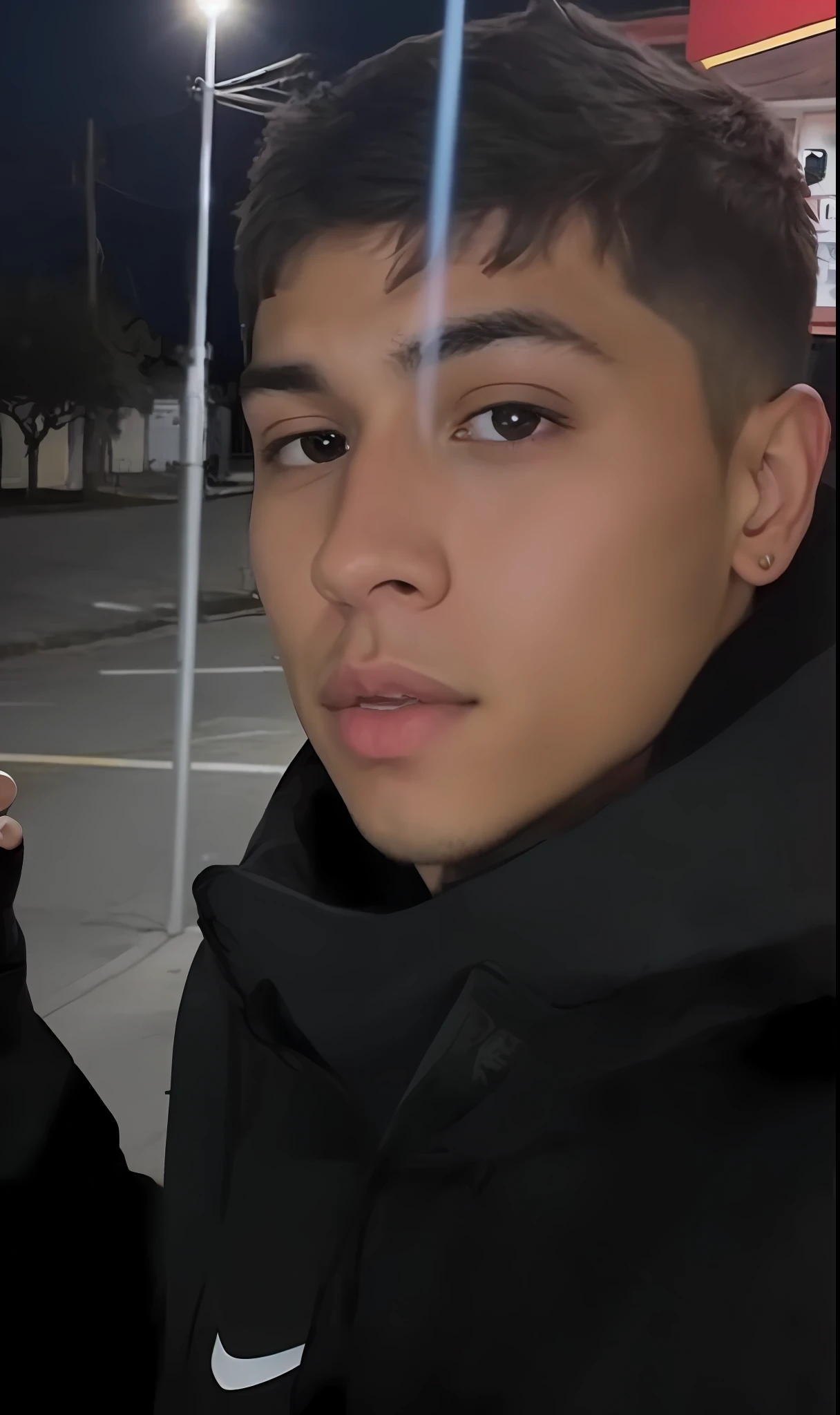 There's a guy holding a cell phone in his hand, taken in early 2020, front photo, around 1 9 years old, he's about 20 years old, he's about 2 0 years old, lit on the side, smooth in the background, very low quality photo, Instagram post, Flying