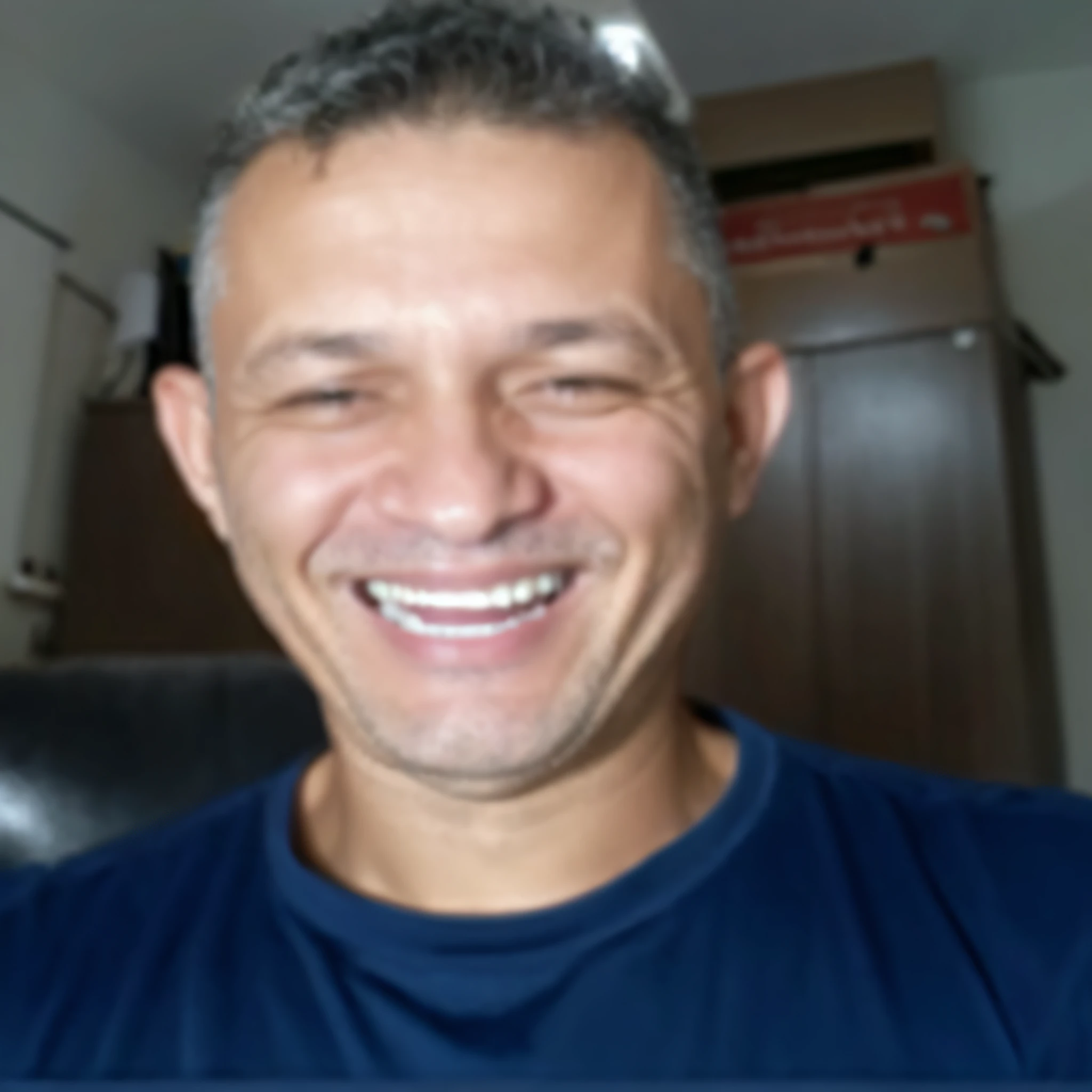 smiling man with a blue shirt and a black chair in a room, david rios ferreira, carmelo blandino, frontal picture, edu souza, caio santos, icaro carvalho, 45 years old men, dan dos santos, ronaldo nazario fenomeno, 4 0 years old man, foto realista, luiz escanuela, avatar image