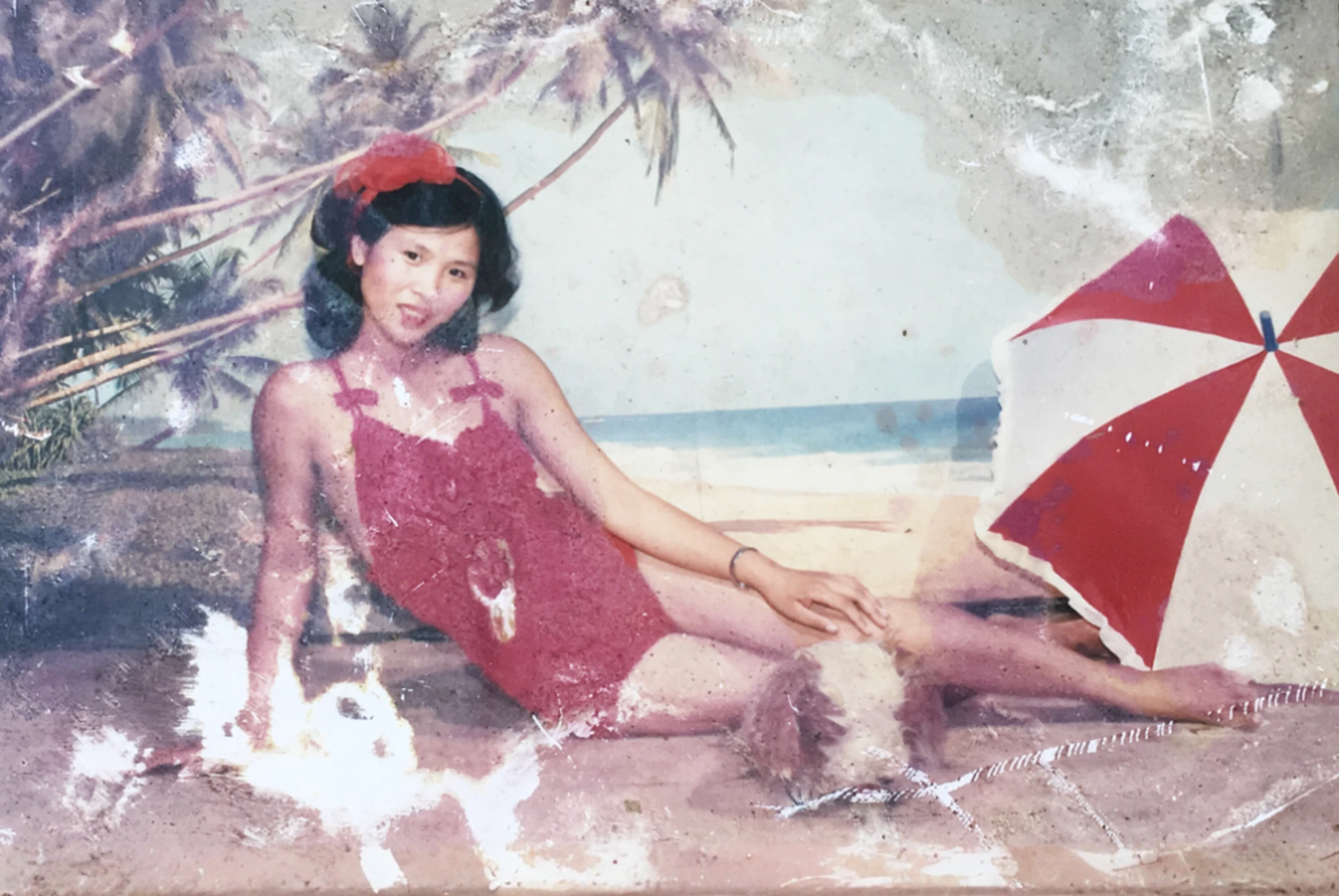 On the beach sits a woman in a red swimsuit, unknown artist, damaged photo, old photo, old color photo, old photo, unknown location, Mai Anh Tran, old painting, photo taken on 2 0 2 0, very old photo, photo of a woman, lost photo, realistic old photo, scattered old photo, repair arm, improve quality