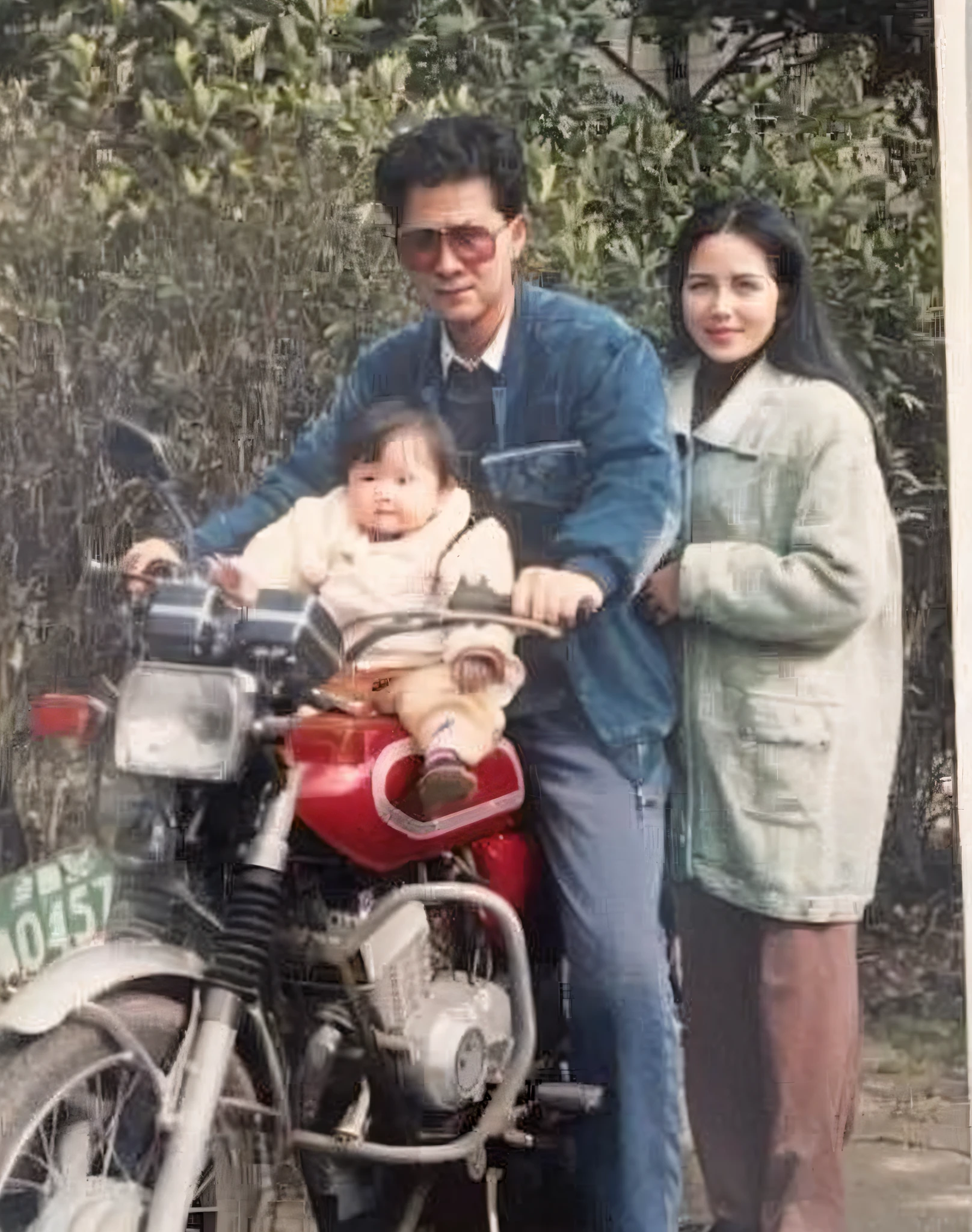 there is a man and woman and a on a motorcycle, momma and papa, he is about 30 years old, he is about 3 0 years old, photo from the 80s, sitting on a motorcycle, riding a motorcycle, he is about 2 5 years old, he is about 40 years old, he is about 4 0 years old