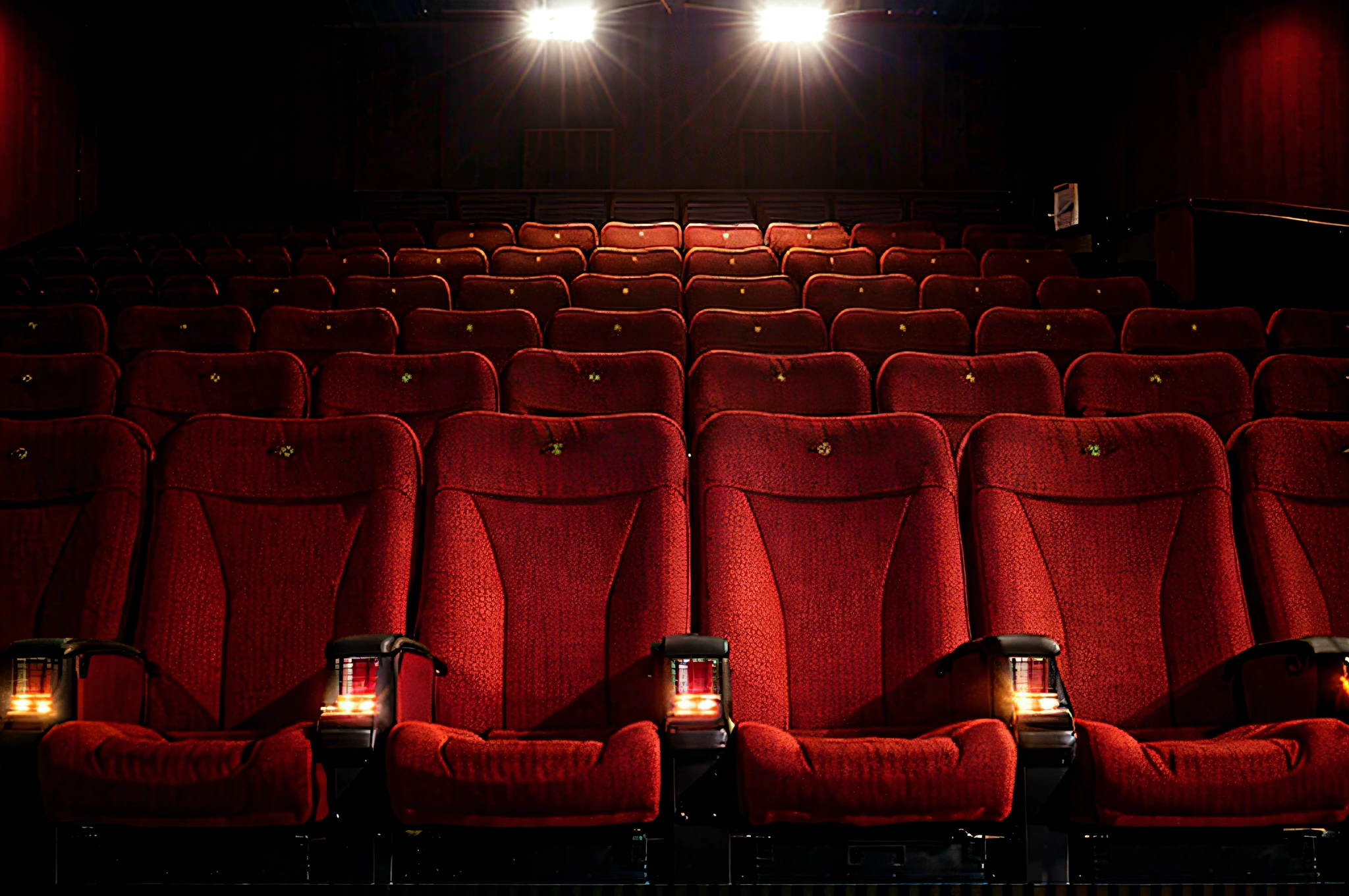 there are many red seats in the theater with a bright light, sitting in a movie theater, in a cinema, cinema lighting, award-winning cinema, photo of the cinema screen, cinematic and dramatic red light, cinema, cinematic movie image, cinématique”, red and cinematic lighting, cinematic view from lower angle, cinematographic wide angle shot, movie lights --auto --s2