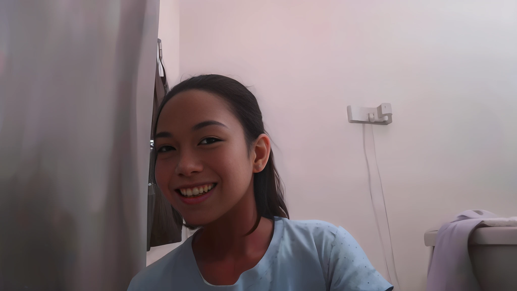 smiling girl in blue shirt sitting in front of a curtain, with a beautifull smile, slight cute smile, friedly smile, with long hair, half onesided smile, selfie!!!!!, blurry image, selfie photo, she is about 1 6 years old, desaturated!!, wry smile, foto, portrait!!!!!!, she is smiling, panting, slight smile