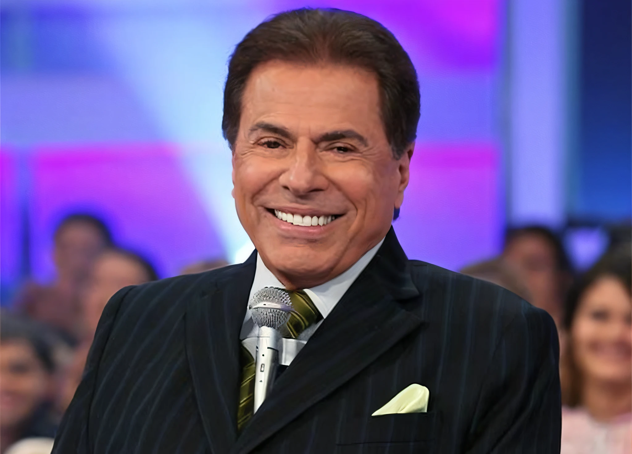 arafed man in a suit and tie smiling while holding a microphone, silvio santos, eddie del rio, heraldo ortega, pepe moreno, ricardo milos, kenneth copeland, roge antonio, mario martinez, carlos ortega elizalde, sidney lugo, richard taddei, ignacio fernandez rios, ignacio rios, roguish smirk