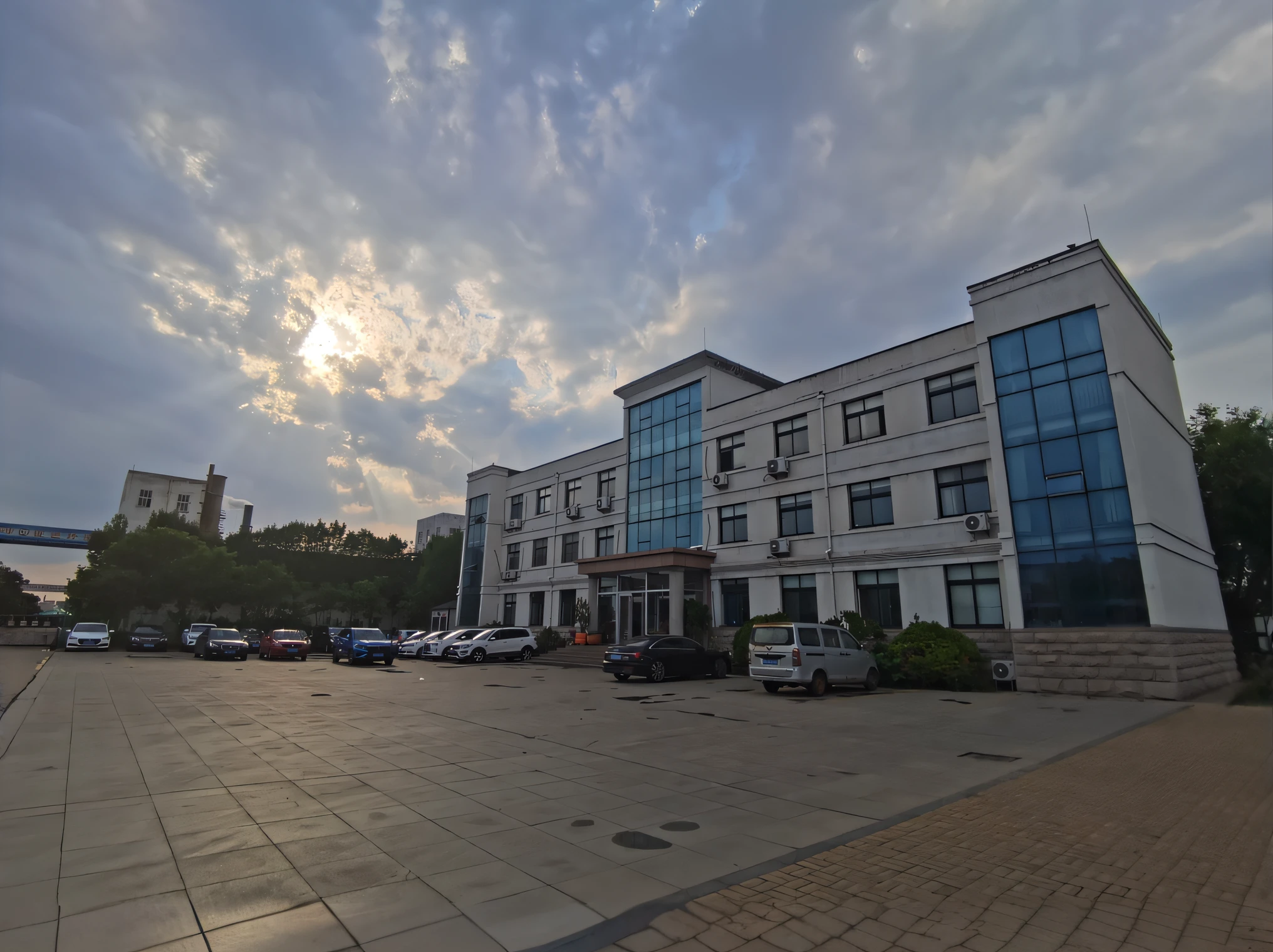 there is a large building with a lot of cars parked in front of it, wide view, office building, taken with sony alpha 9, wide - angle view, wide-angle view, taken with sony a7r camera, captured with sony a3 camera, hdr shot, wide-angle shot, wide - angle shot, the sun is shining wide shot