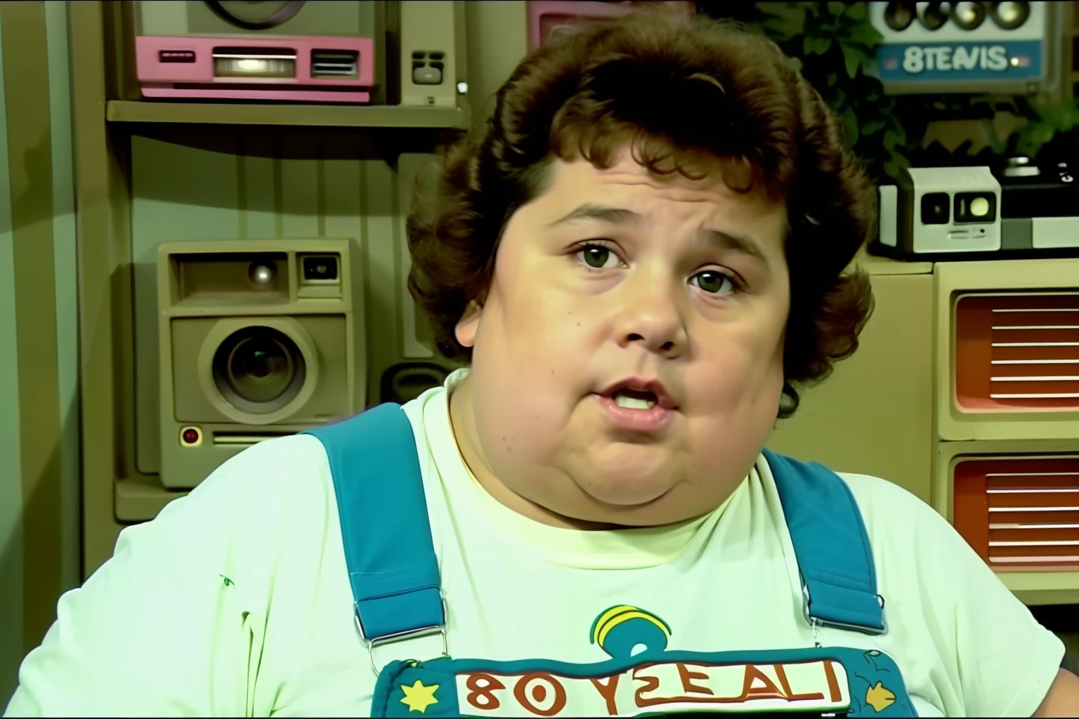 (((vhs screengrab, shot on a broadcast camera, a live-action 80’s sitcom))) featuring a boy (:1.3), (fat boy:1.3), green overalls, black fringe, scene head diagonally, indoor house background. Reference: friends, Seinfeld, Full house.