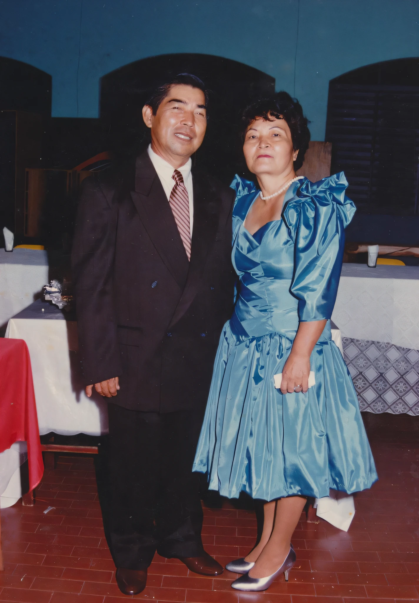 They are standing in a room with tables and chairs, Mom and Dad, photo 1 9 9 0 s, photo 1980s, photo 1 9 8 0 s, taken in the late 1980s, photo of the 80s, photo taken in 1989, of more quality photo