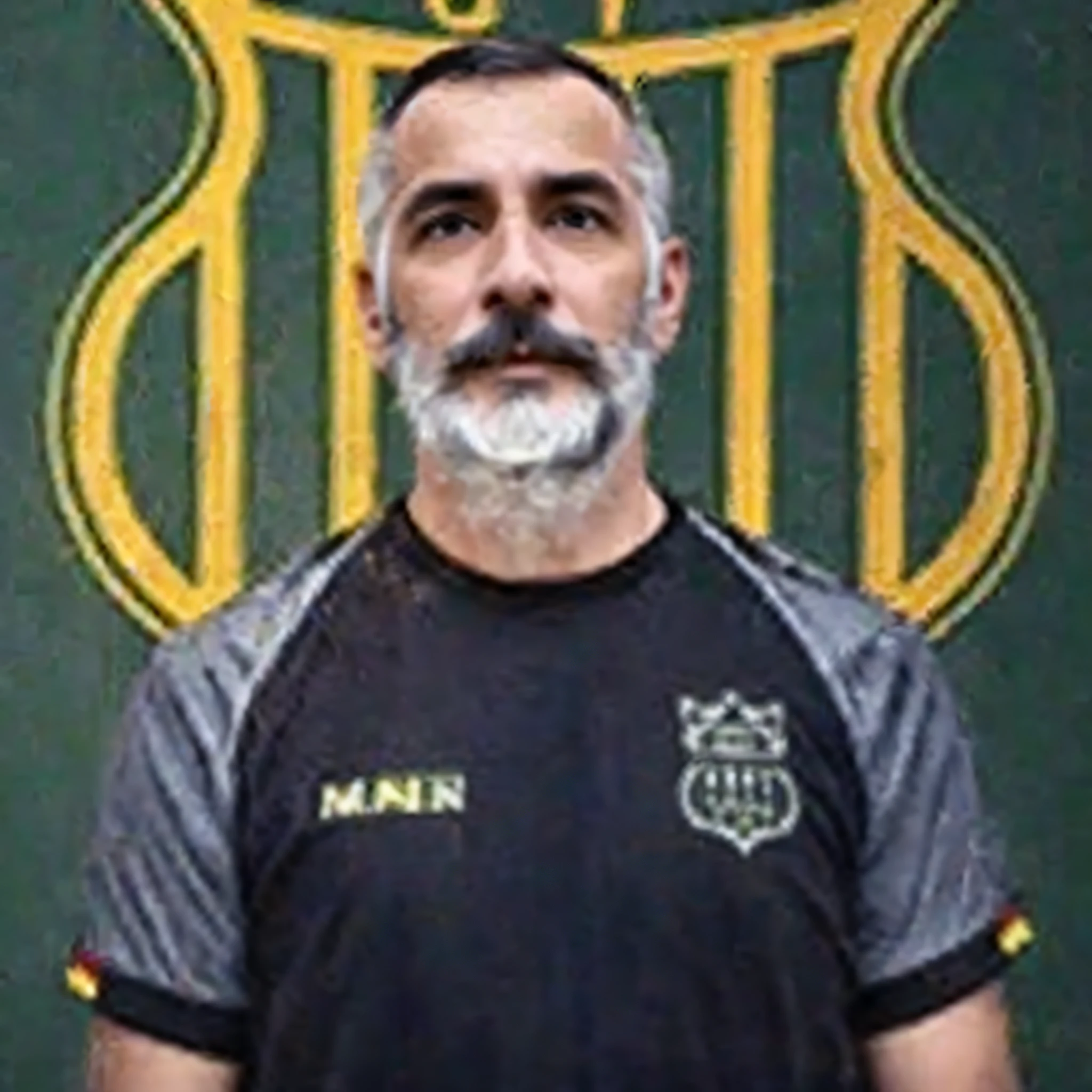 Man with beard and mustache in front of a green and yellow sign,