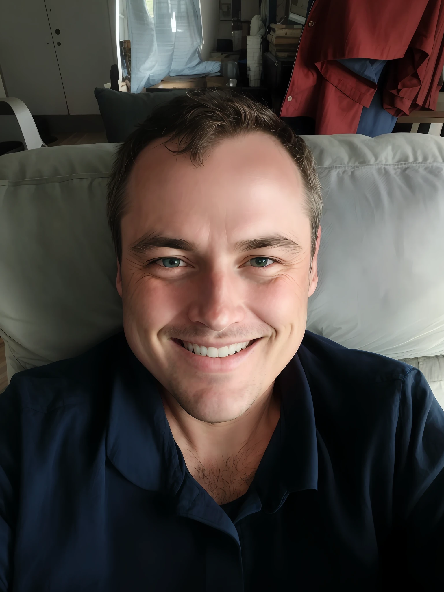 Smiling man sitting on a couch in a blue shirt, 3 6 years old, relaxing and smiling at the camera