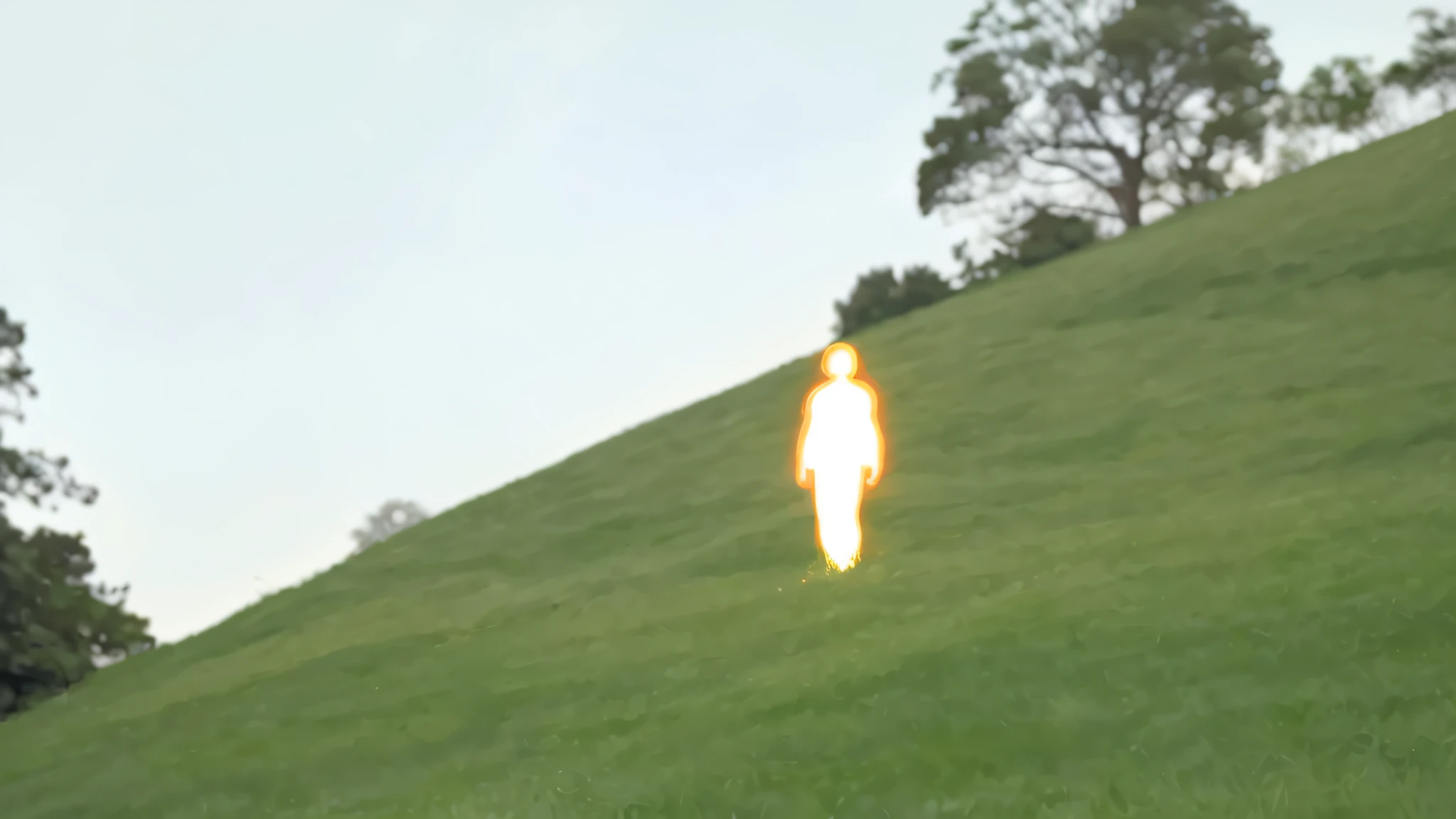 Human body made of orange light standing on a green lawn, photograph