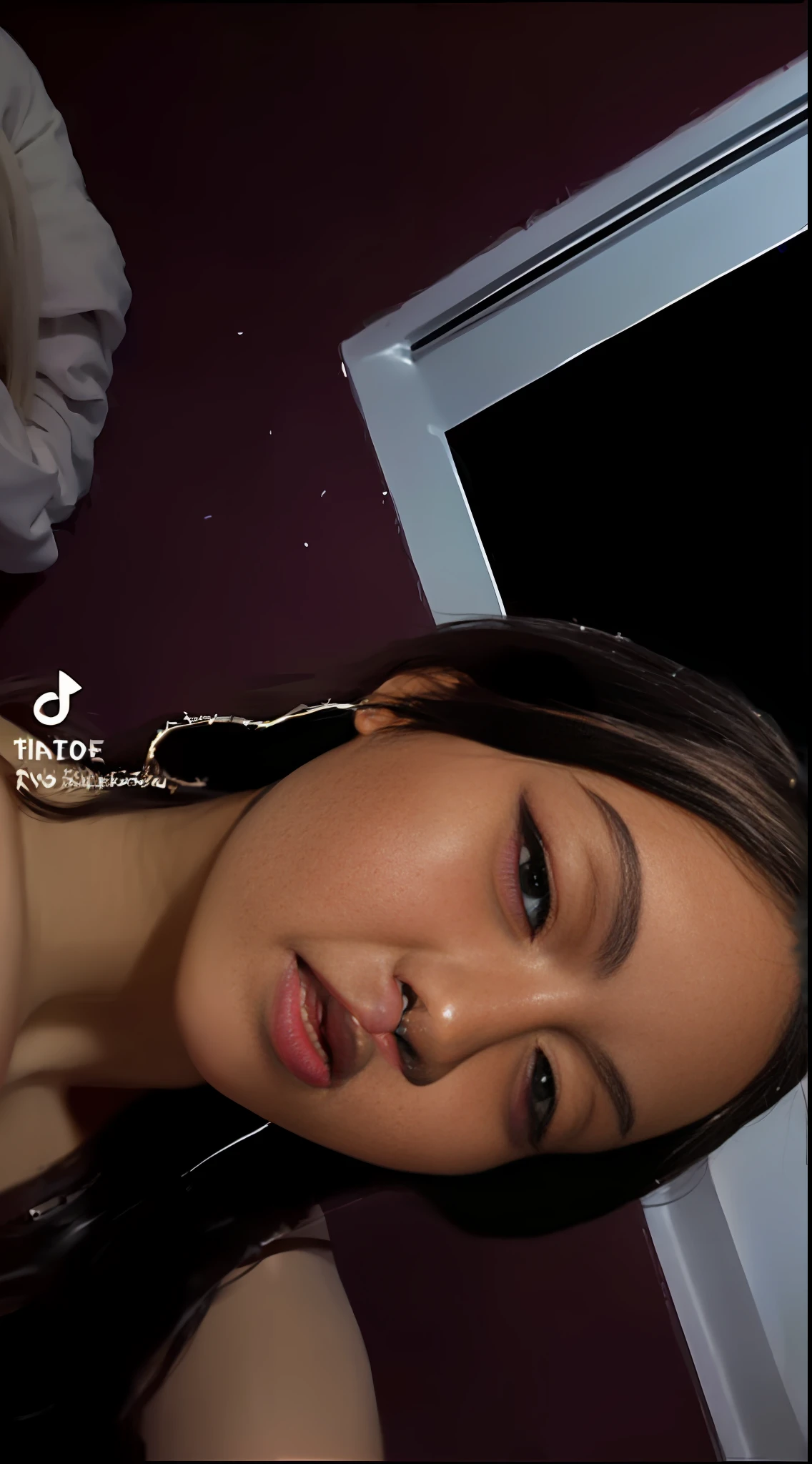 a close up of a woman with long hair wearing a black top, tiktok video, detailed flawless face, she has a glow coming from her, she is about 1 6 years old, instagram story, she is facing the camera, trending on tiktok, low quality video, she has a cute face, ☁🌪🌙👩🏾, she has olive brown skin