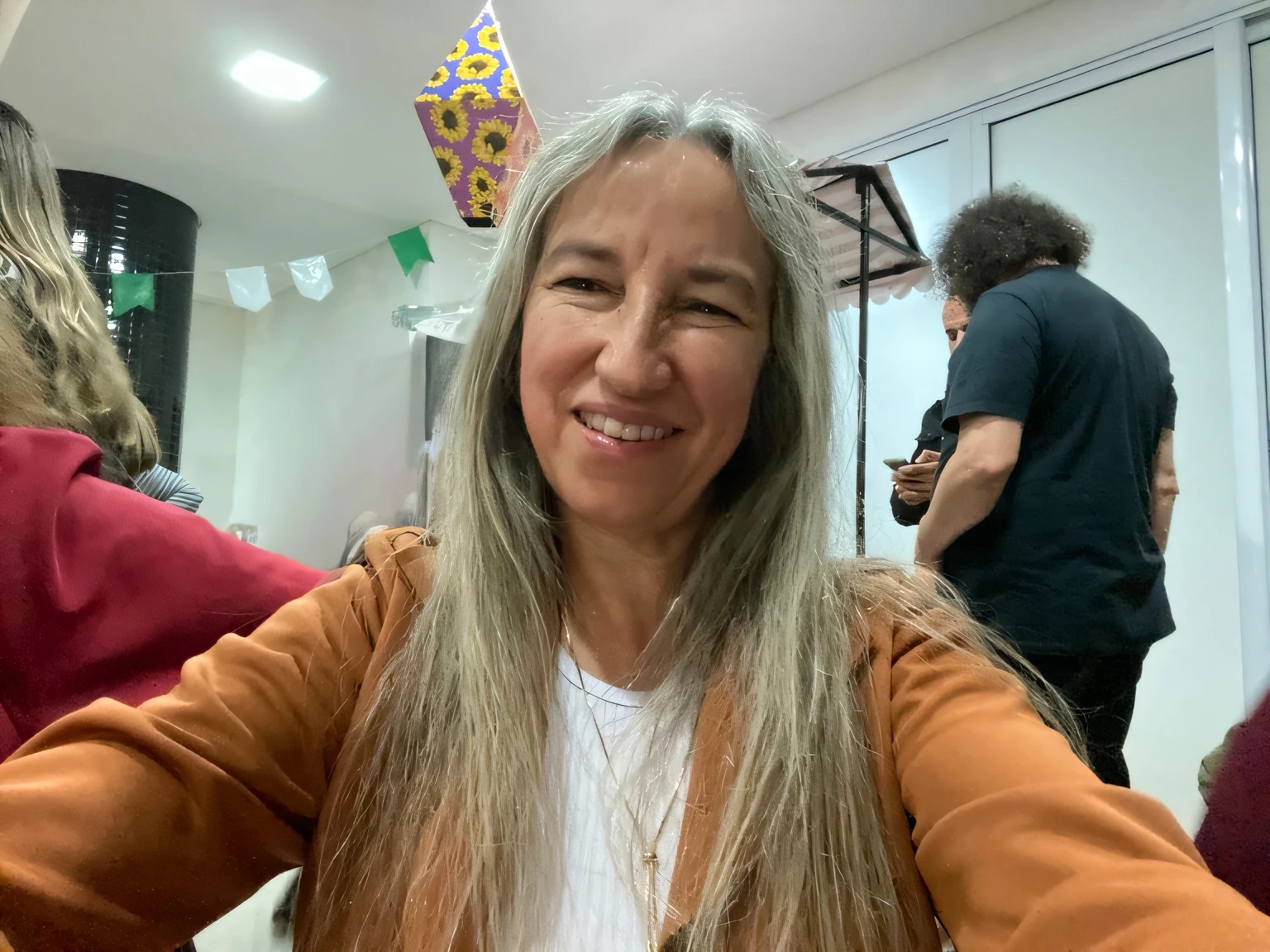 mulher sorridente com longos cabelos grisalhos sentada em uma mesa com um bolo, Direction: Nandor Soldier, imagem de perfil, Caroline Gariba, fernanda suarez, Direction: Amédée Ozenfant, Magda Torres Gurza, longos cabelos grisalhos, happily smiling at the camera, Monserrat Gudiol, she is smiling and happy