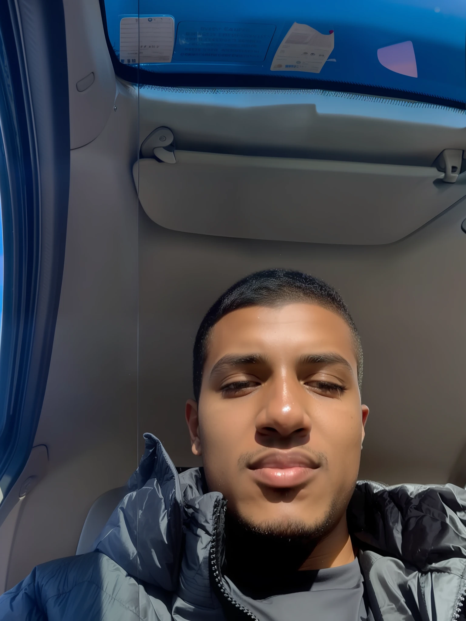 there is a man sitting in the back seat of a car, around 1 9 , taken in the early 2020s, with brown skin, frontal picture, 8k selfie photograph, very very low quality picture, riyahd cassiem, good looking face, looking away from camera, detailed unblurred face, selfie of a man, perfectly clear face