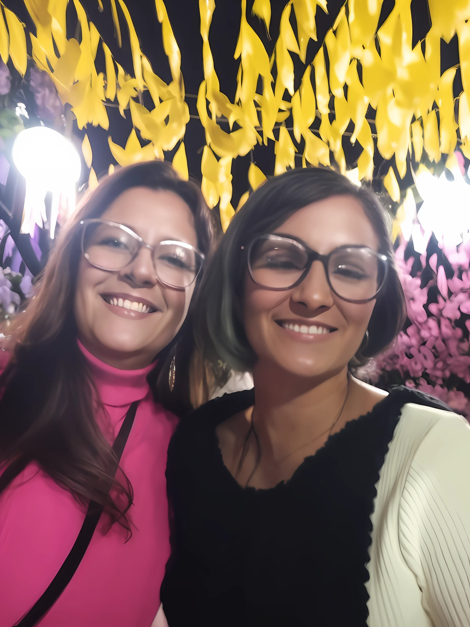 two women standing next to each other in front of a wall of flowers, by Nándor Katona, photo taken at night, in sao paulo, not blurry, pov photo, in a candy forest! at night, by Márta Lacza, by Gina Pellón, both smiling for the camera, fernanda suarez, having a great time