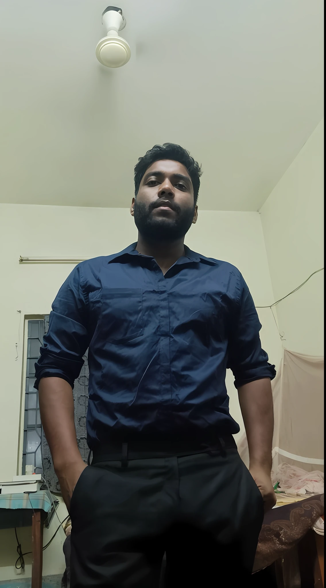 there is a man standing in a room with a blue shirt, full body picture, with accurate face, very very low quality picture, menacing look, jayison devadas, taken with sony alpha 9, full body profile camera shot, vinayak, cinematic full shot, wearing in shirt, frontal pose, 4 0 years old man, in a menacing pose