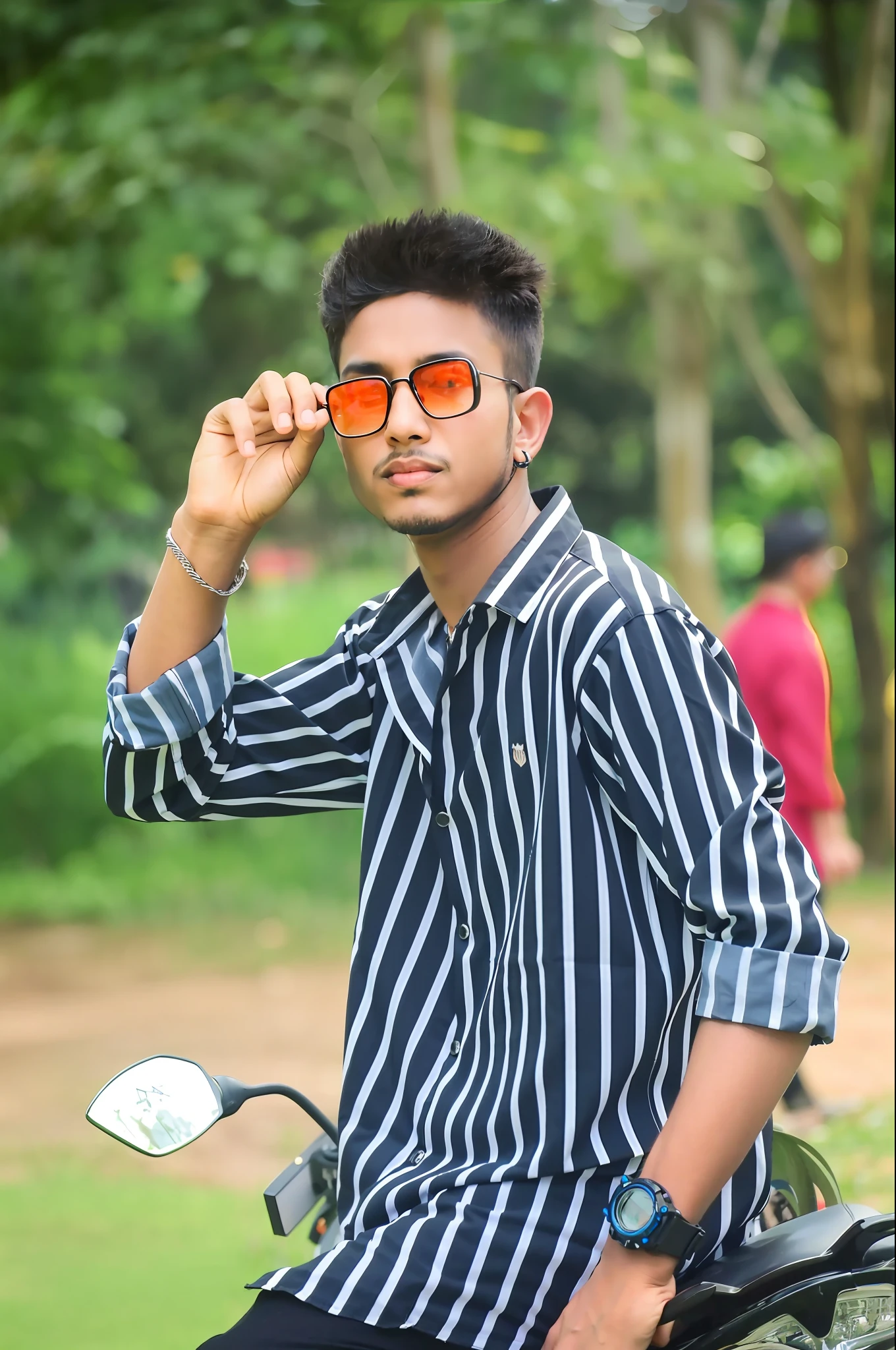 there is a man that is sitting on a motorcycle with sunglasses on, with sunglass, jayison devadas style, casual photography, jayison devadas, candid picture, stylish pose, shot on nikon z9, modeling photography, wearing orange sunglasses, with a cool pose, assamese aesthetic, with sunglasses, cool pose, * colour splash *, candid photography
