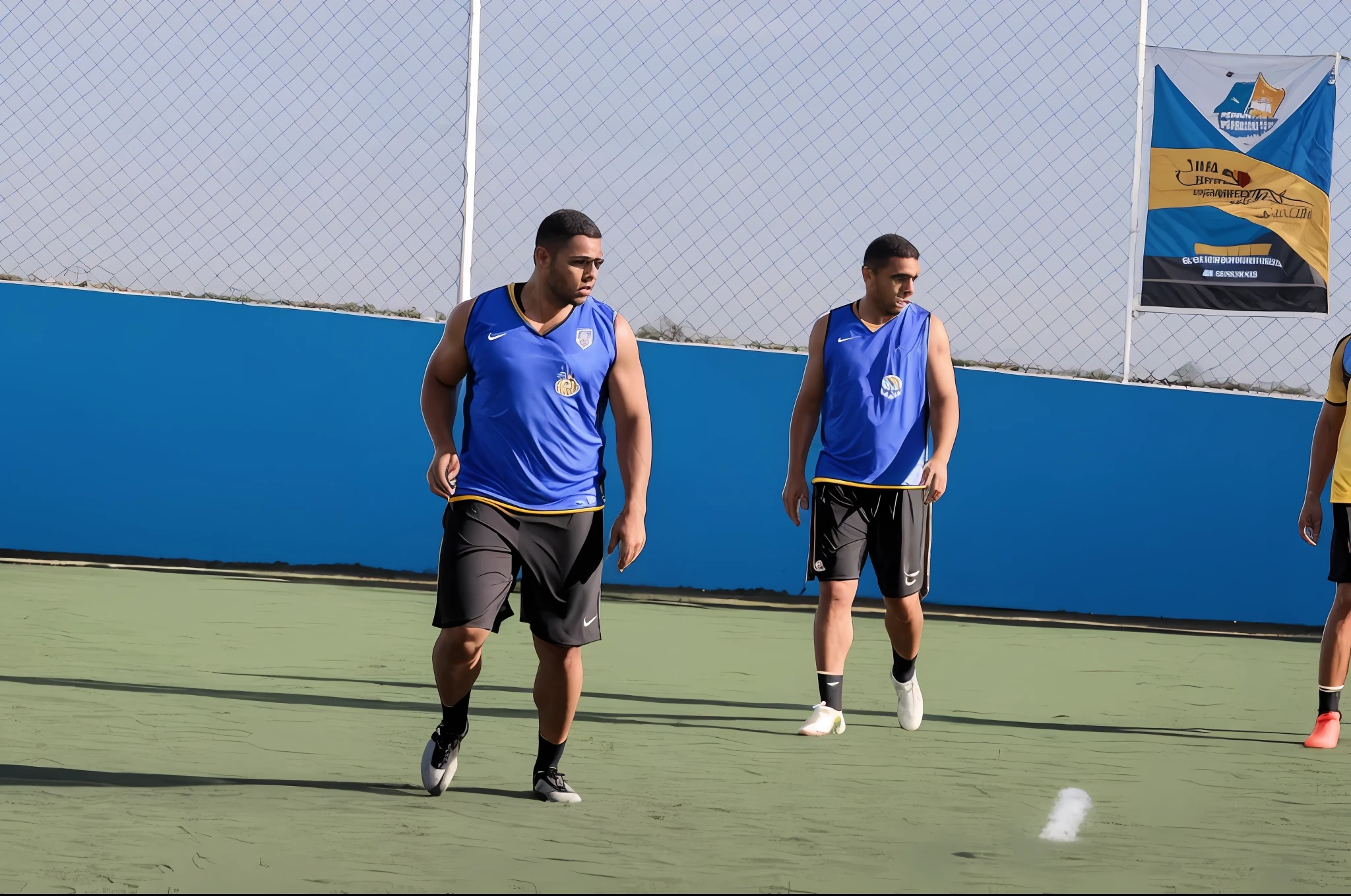 several men are playing soccer on a green field with a fence, em campo, foco em primeiro plano, Correndo, Motivacional, Directed by: Samuel Silva, mid - action, tiro focado, desporto, futebol, malhar no campo, Meio - tiro, Tiro no meio, em um campo de futebol, foco no primeiro plano, camaradagem, combinar, sombrio
