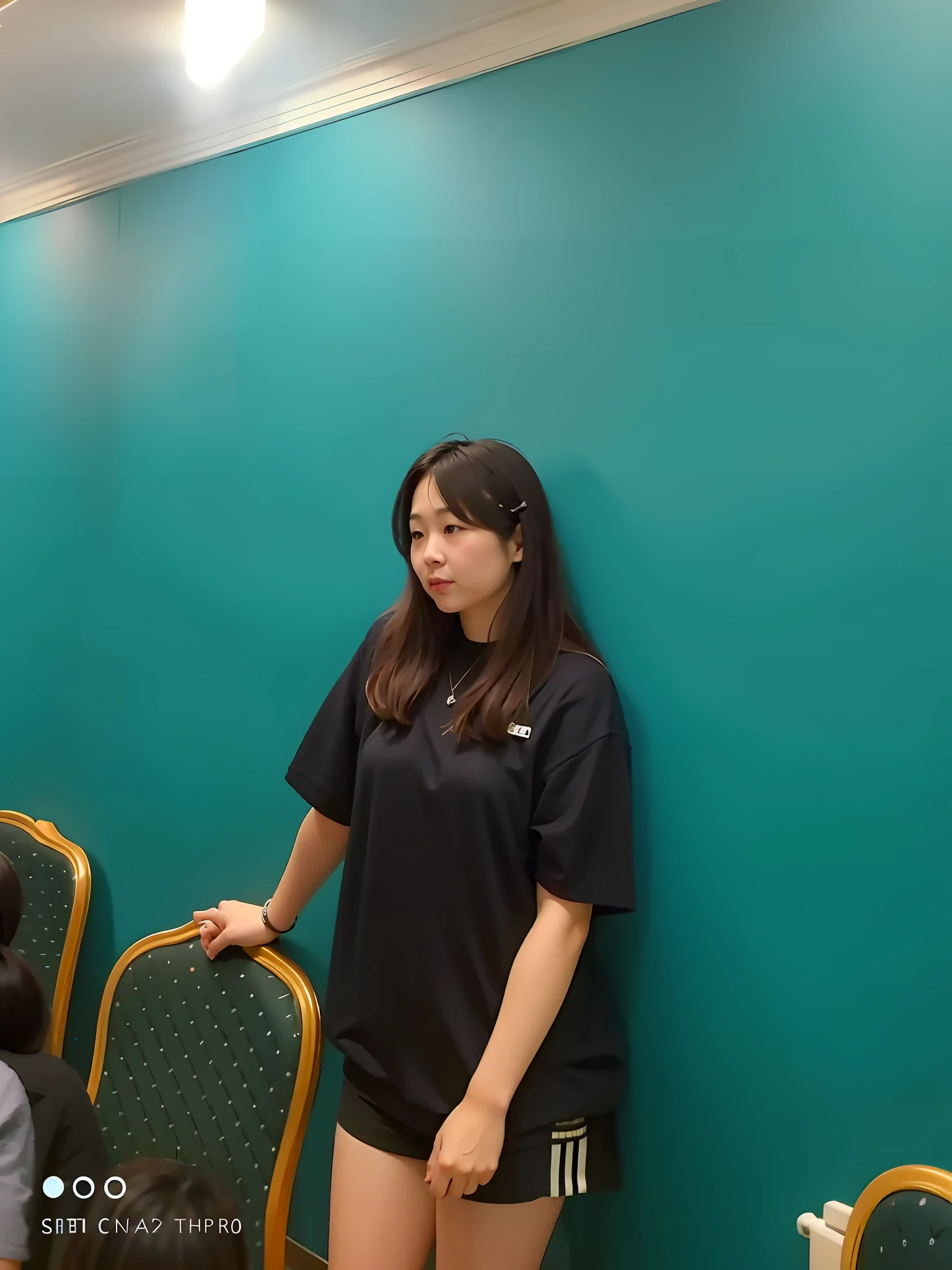 there is a woman that is standing in front of a wall，Hold the remote control, chinese artist, xintong chen, standing in class, very very low quality picture, wenfei ye, looking away from camera, Lin Qifeng, shot on iphone, in a meeting room, coloured photo, Zhang Wanting, wenjun lin, Wearing a black shirt, korean artist
