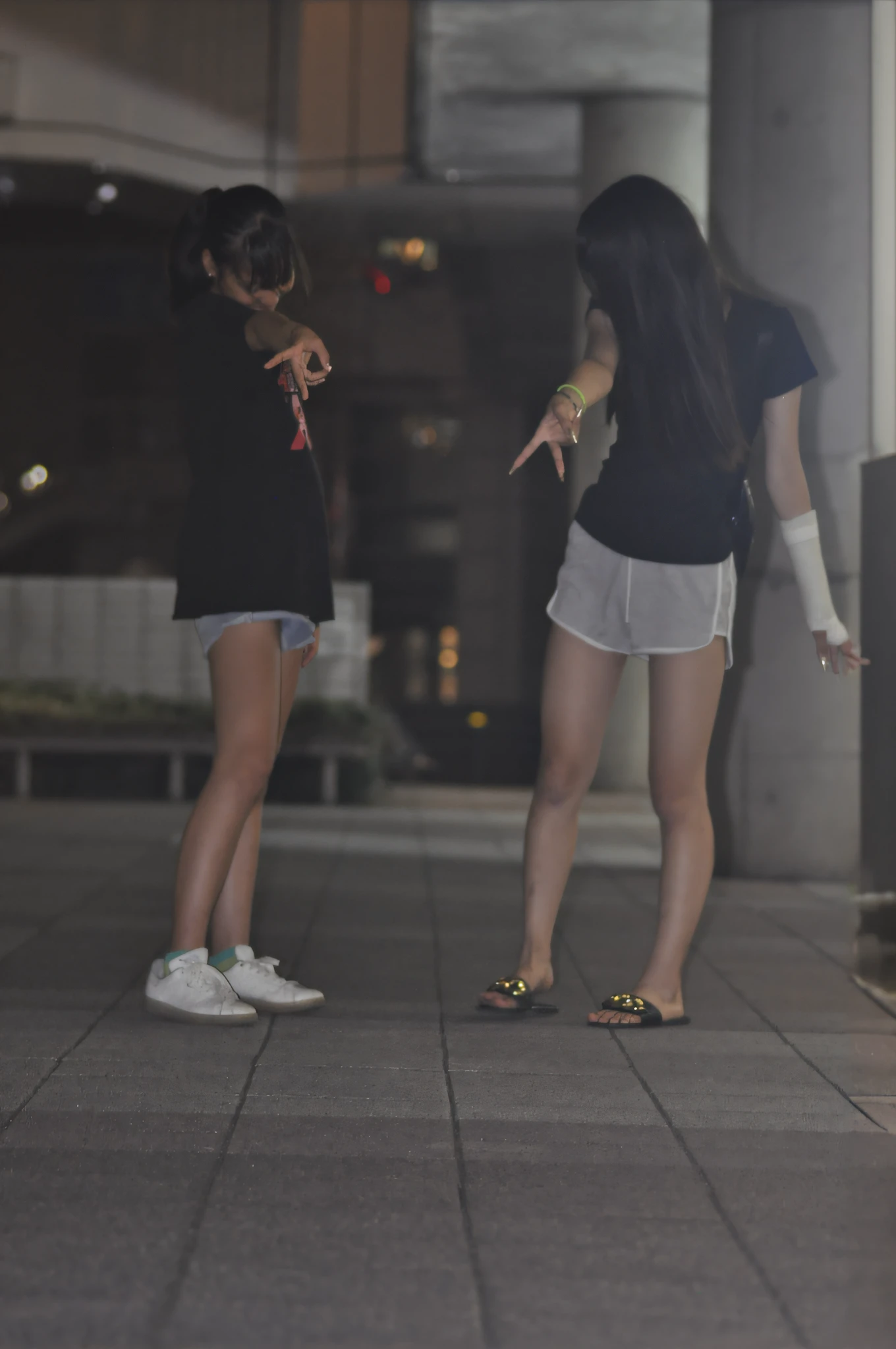 there are two women standing on the sidewalk pointing at something, taken with a canon eos 5 d, taken with a canon eos 5 d, taken with a canon eos 5d, Night Man々, summer evening, girls resting, night photo, Two girls, on rooftop tokyo night, shot at night, taken with canon 8 0 d, in a tokyo street