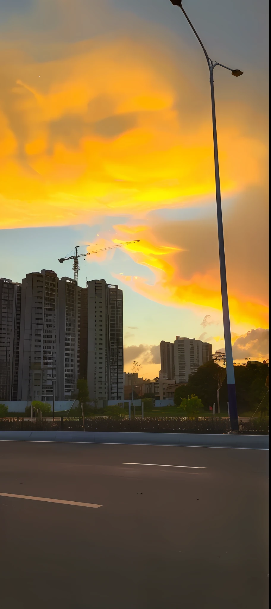 late sunset,Street lamps and tall buildings on the city streets mingle。Shot with iPhone 13 Pro Max primetime,The photo shows the vigor of a tall building in the distance,The whole picture has a faint twilight。City streets loom,The color rendering at dusk brings out the unique atmosphere of the city。