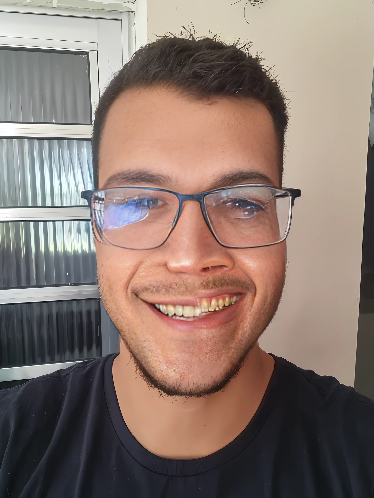 Smiling man with glasses and a black shirt in front of a window, caio santos, imagem frontal, leve sorriso nerd, icaro carvalho, david rios ferreira, Directed by: Nandor Soldier, blue symmetric eyes 24yo, José Moncada, Fotografia selfie 8k, Henry Alvim Correa, sorrindo e olhando diretamente