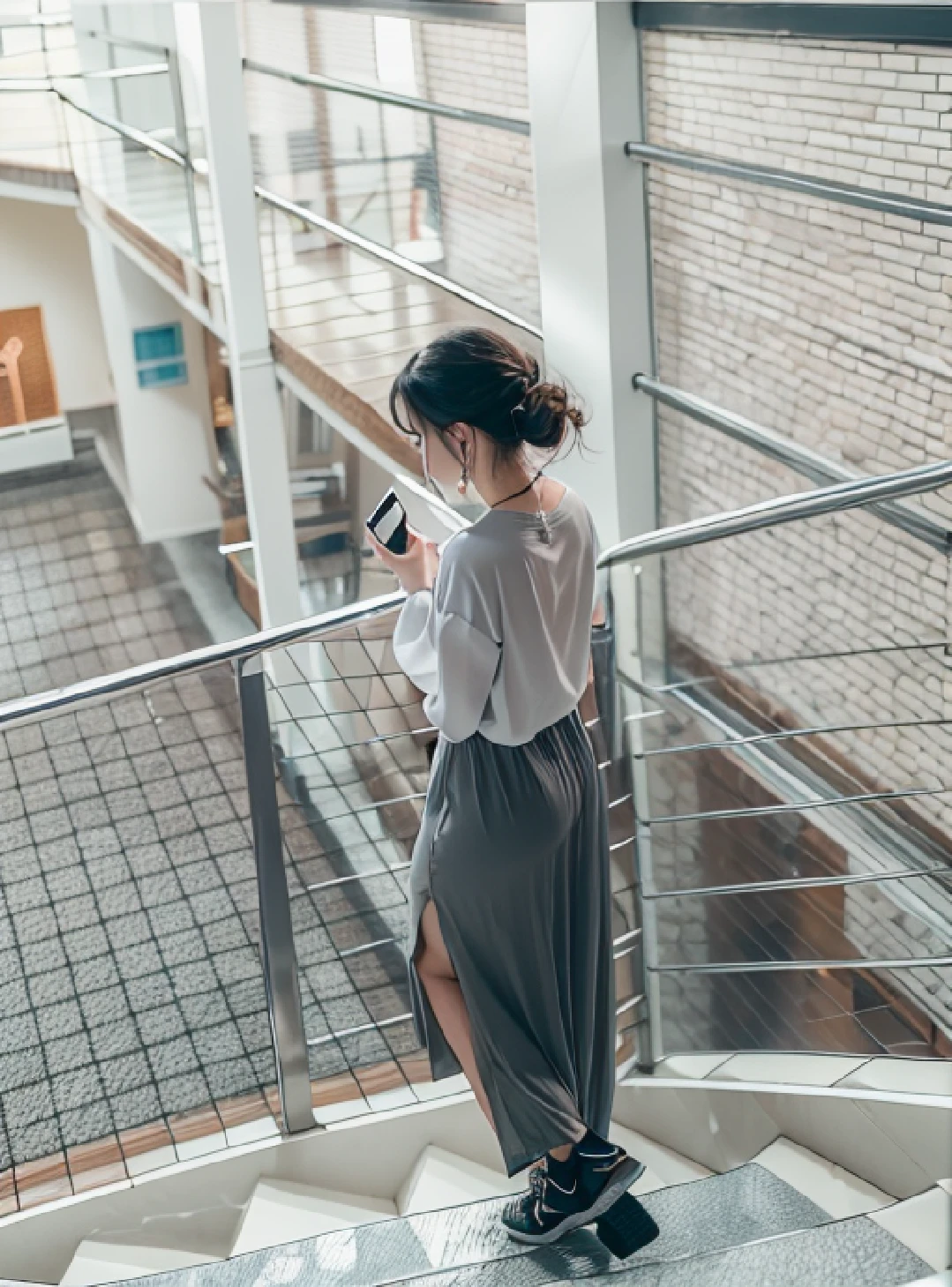 There was a woman standing on the stairs looking at her phone, Long dress, transparent gray skirts, light half opened dress, simple dress, Long skirt, Back - View, dressed with long fluent clothes, soft silk dress, white shirt and grey skirt, full - length view, Long shirt, Transparent gray dress, Gray color, Women's long skirt