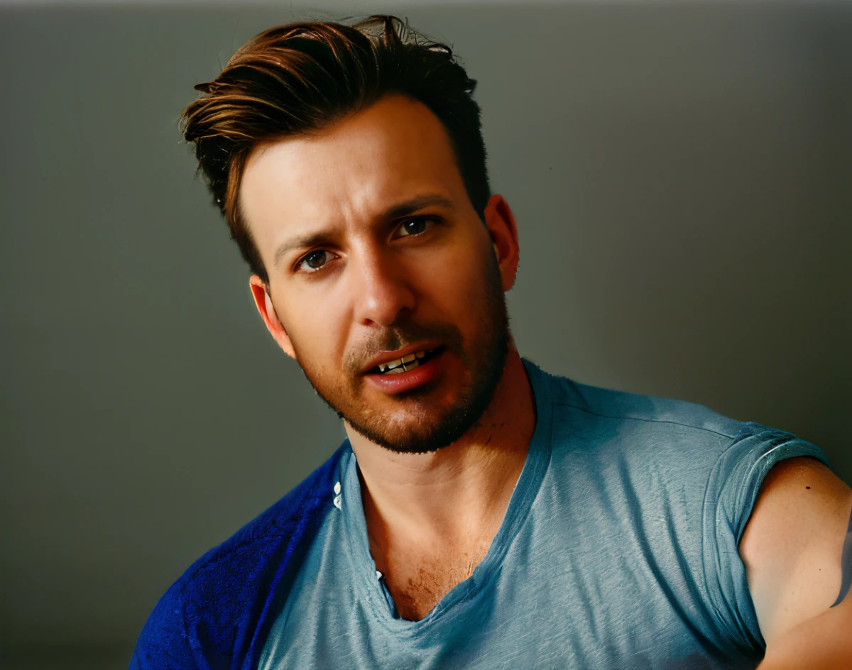 Retrato de Chris Evans, usando uma camiseta azul, com fundo em branco