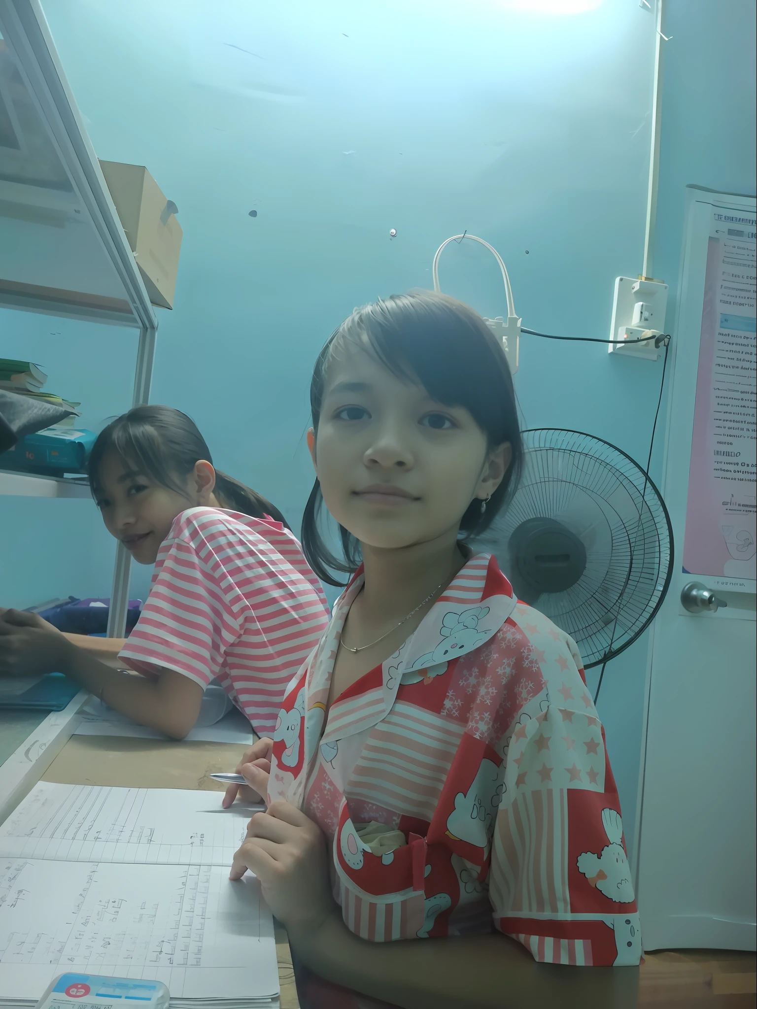 there are two girls sitting at a table with papers and a fan, photo of the girl, dang my linh, in office, old picture, nivanh chanthara, a picture, very very low quality picture, student, hoang long ly, she is smiling and happy, captured on iphone, protrait, captured with sony a3 camera, in laboratory