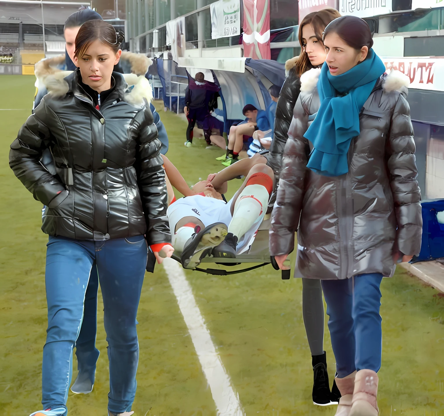 a soccer scene in a sports stadium, cool and wet weather conditions, humide ground, rainy sky, injury scene in a sports stadium, stretcher carry, there are four female medics carrying a stretcher, there are four female medics in very shiny coats who are carrying a stretcher in a sports stadium, there is a wounded male soccer player in a matte short cotton sports outfit lying on the stretcher, an injured male soccer player in matte cotton sportswear is lying in pain on a stretcher, a soccer player in matte cotton sports clothes is rearing up in intense pain while lying on a stretcher, dramatic scene, theatralic posing scene, dramatic pity scene, injury soccer, first aid, help, pity, there are four female medics in wetlook high-shine coats who are looking very sad and very terrified and very shocked, the injured soccer player is screaming out in pain while he is carried from the pitch on a stetcher