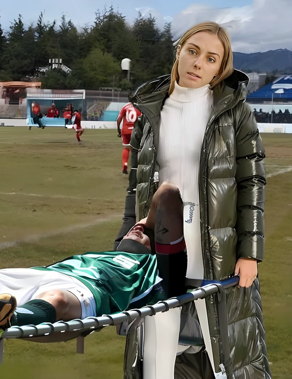 a soccer scene in a german sports stadium, injury scene in a sports stadium, stretcher carry, an injured soccer player is lying head first on his back on a stretcher and is covering his head with the hand, there are four young schoolgirls in shiny leather-trousers carrying a stretcher, there are four longhaired schoolgirls in high-shine latex-leggings who are carrying a stretcher in a german sports stadium, there is a wounded male soccer player in a short sports outfit lying head first on the stretcher, an injured male soccer player is lying head first on his back on a stretcher and is covering his agonised face with a hand, a soccer player is rearing up in intense pain while lying head first on his back on a stretcher and covering his head with a hand, dramatic scene, theatralic posing scene, dramatic pity scene, injury soccer, first aid, help, pity, there are four very angry looking schoolgirls in shiny latex-trousers who are looking very sad and very terrified and very shocked, the injured soccer player is screaming out in pain while he is carried from the pitch on a stretcher