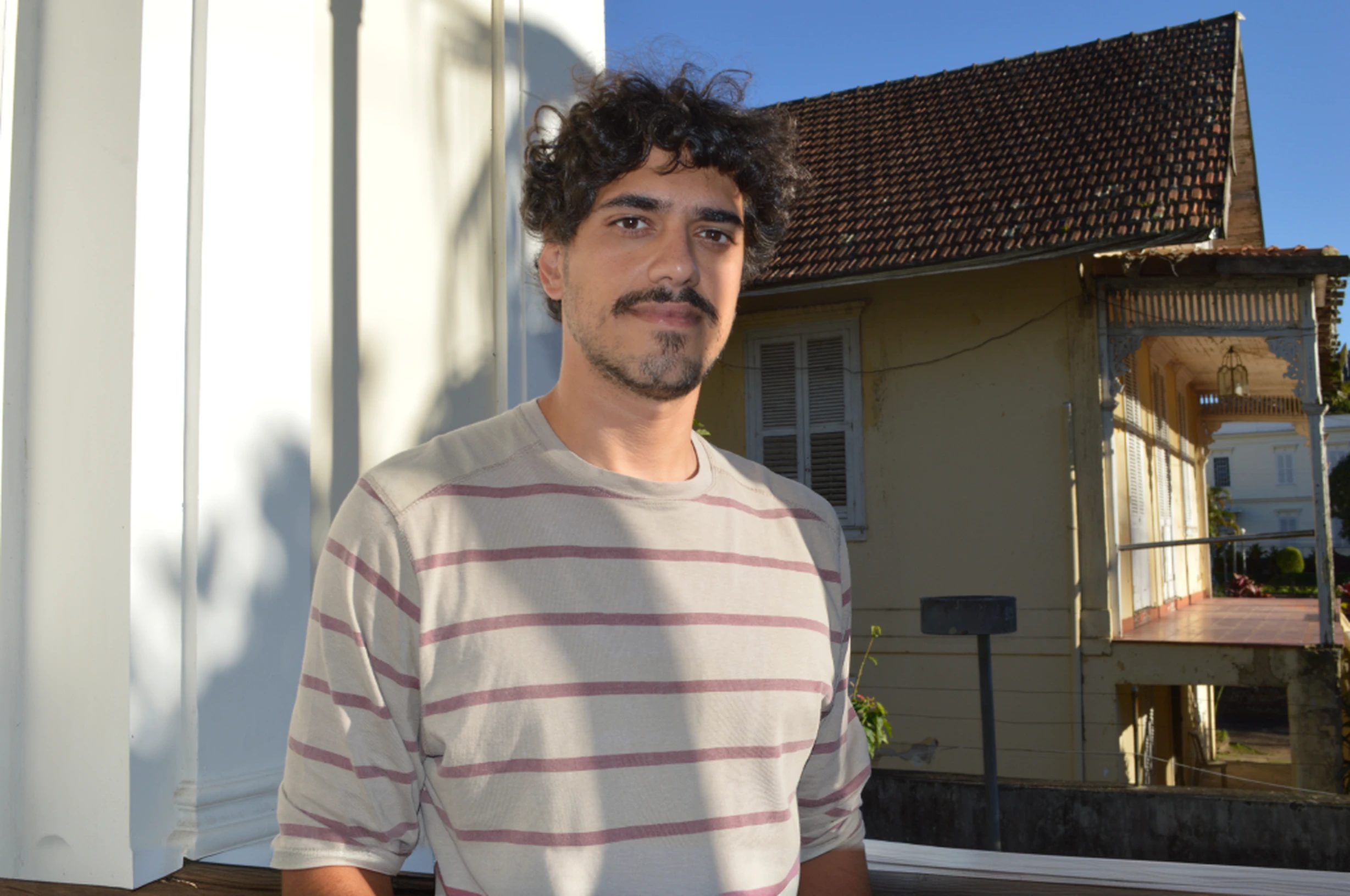 Arafed man standing on a porch with a dog in the background, icaro carvalho, david rios ferreira, Condutor de Ene, emanuele dascanio, Carmelo Blandino, caio santos, by João Artur da Silva, Henry Alvim Correa, imagem retrato, Federico Pelat, edu souza