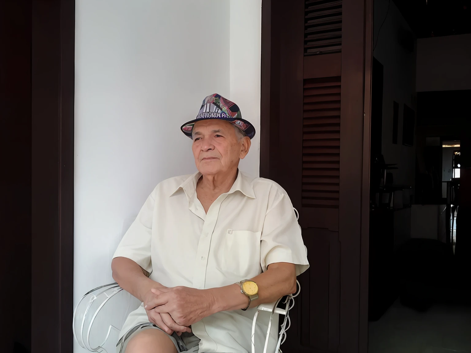 There's a man sitting in a chair with a hat on, ele tem cerca de 8 0 anos de idade, old man, senor salme, wearing a travel hat, ele tem cerca de 7 0 anos de idade, um homem de 80 anos, José Moncada, he is wearing a hat, ástor alexander, Retrato de um velho, um velho