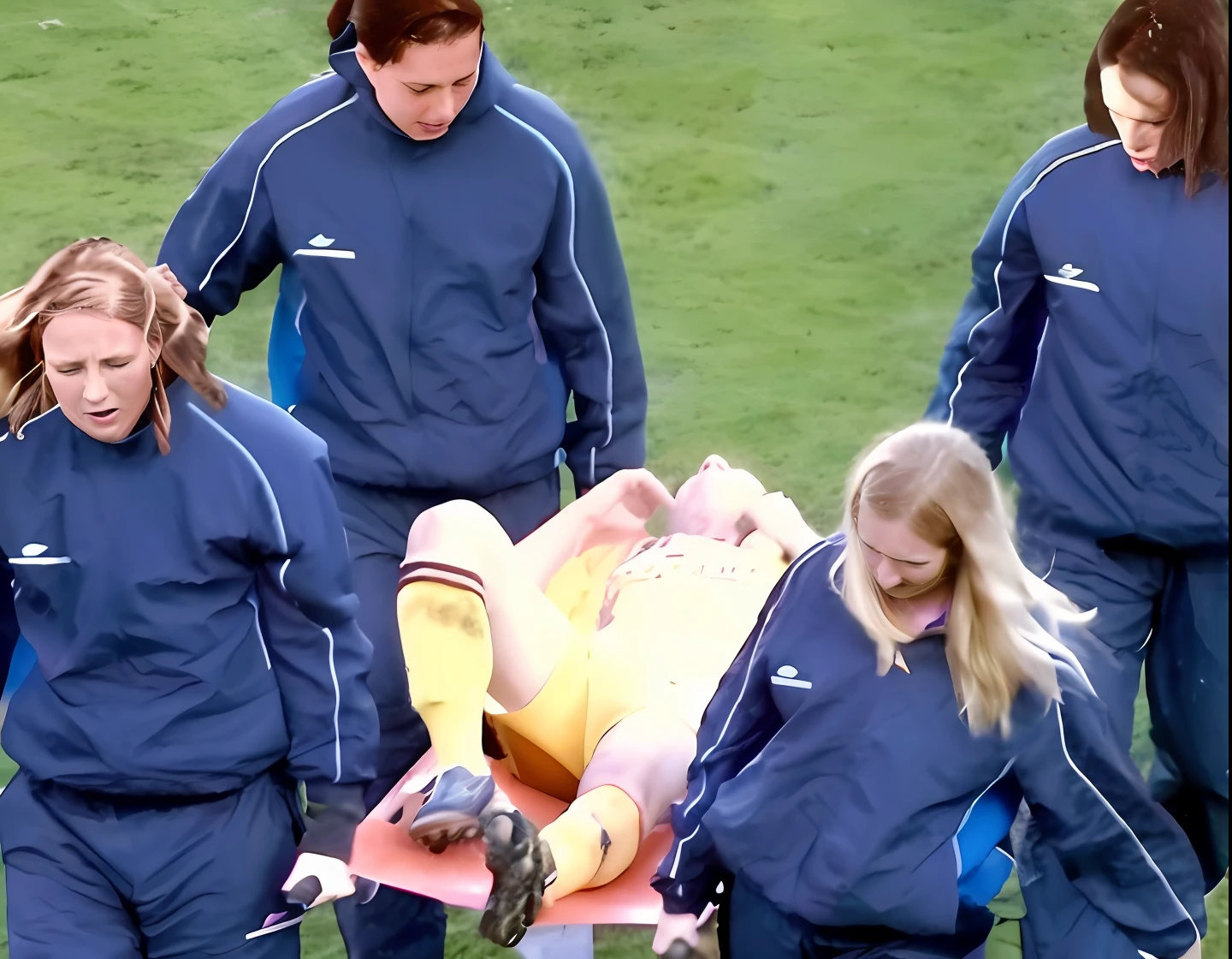 a soccer scene in a sports stadium, cool and wet weather conditions, humide ground, rainy sky, injury scene in a sports stadium, stretcher carry, there are four female medics carrying a stretcher, there are four female medics in very shiny coats who are carrying a stretcher in a sports stadium, there is a wounded male soccer player in a matte short cotton sports outfit lying on the stretcher, an injured male soccer player in matte cotton sportswear is lying in pain on a stretcher, a soccer player in matte cotton sports clothes is rearing up in intense pain while lying on a stretcher, dramatic scene, theatralic posing scene, dramatic pity scene, injury soccer, first aid, help, pity, there are four female medics in wetlook high-shine coats who are looking very sad and very terrified and very shocked, the injured soccer player is screaming out in pain while he is carried from the pitch on a stretcher