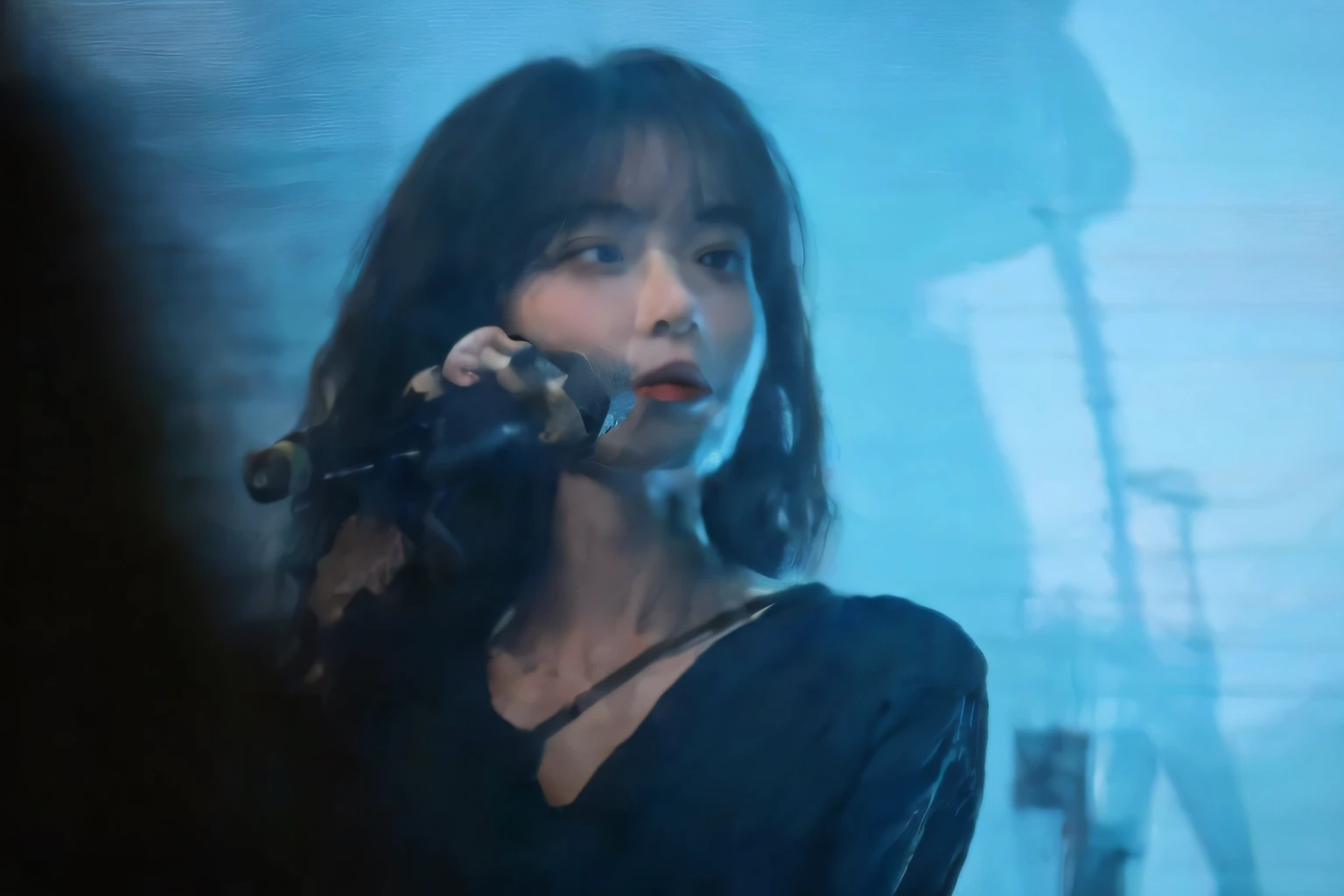 Araki woman in black shirt holding microphone in front of a blue screen, IU, iu lee ji-eun as a super villain, janice sung, sun yunjoo, Concert, Shin Jinying, korean artist, jiyun chae, Performing on stage, Execution, gongbi, concert footage, Live performance,