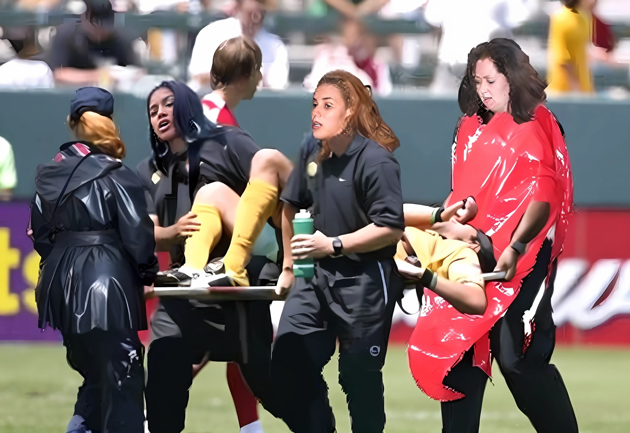 several women are carrying a stretcher with an injured male soccer player lying on it, godesses, injured, hurt, sickly, epic scene, realistic scene, intense scene, an injured soccer player in very matte yellow sportswear is lying on his back on a strether with one hand covering his painful face, painful scene, fetish action, longhaired women in shiny latex clothes are carrying a stretcher on a soccer field, pity, screaming, desperation, pain, agony, shouting, drama