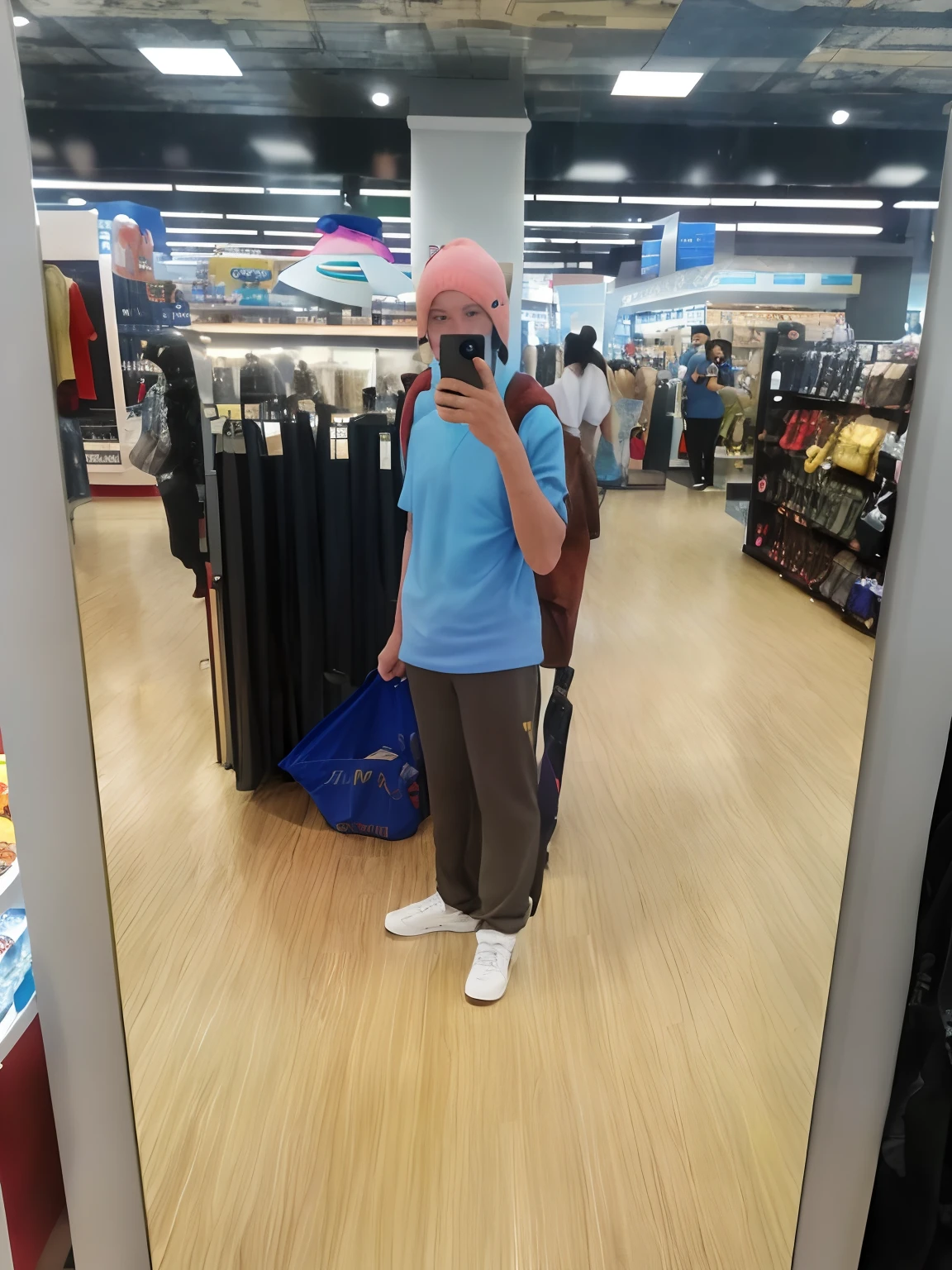 there is a man taking a picture of himself in a mirror, in a mall, stood in a supermarket, appearing in a shopping mall, at a mall, baggy clothing and hat, very very low quality picture, wide angle full body, full body picture, he is about 6 0 years old, he is about 60 years old, wearing a fisher 🧥