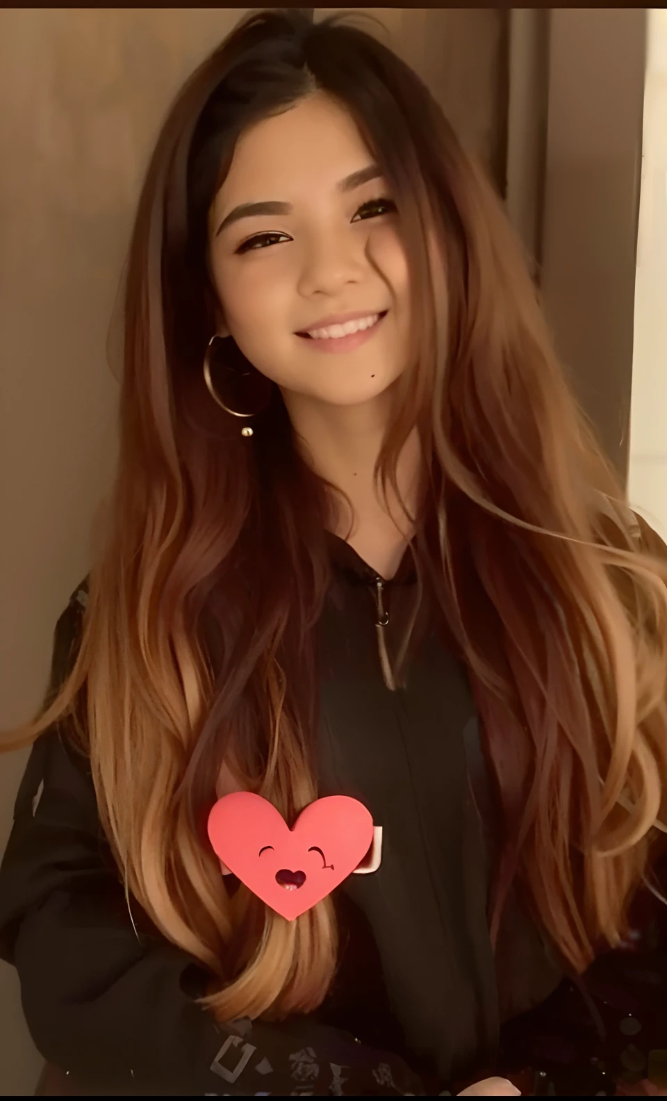 a close up of a person holding a heart shaped object, with long hair, brown long hair with bangs, with lovely look, brown colored long hair, very very low quality picture, with brown hair, ruan cute vtuber, she has long orange brown hair, lovely smile, with a beautifull smile, long hair with bangs, long hair with full bangs