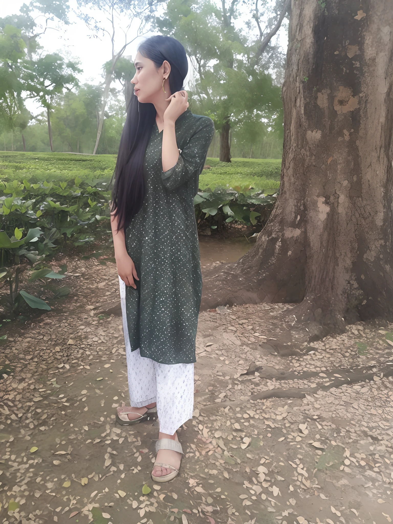 there is a woman standing in front of a tree talking on a cell phone, assamese aesthetic, wearing a kurta, wearing a silk kurta, wearing an elegant tribal outfit, green tunic, inspired by Puru, distant full body view, assamese, * colour splash *, desi, indian style, traditional beauty, standing gracefully upon a lotus