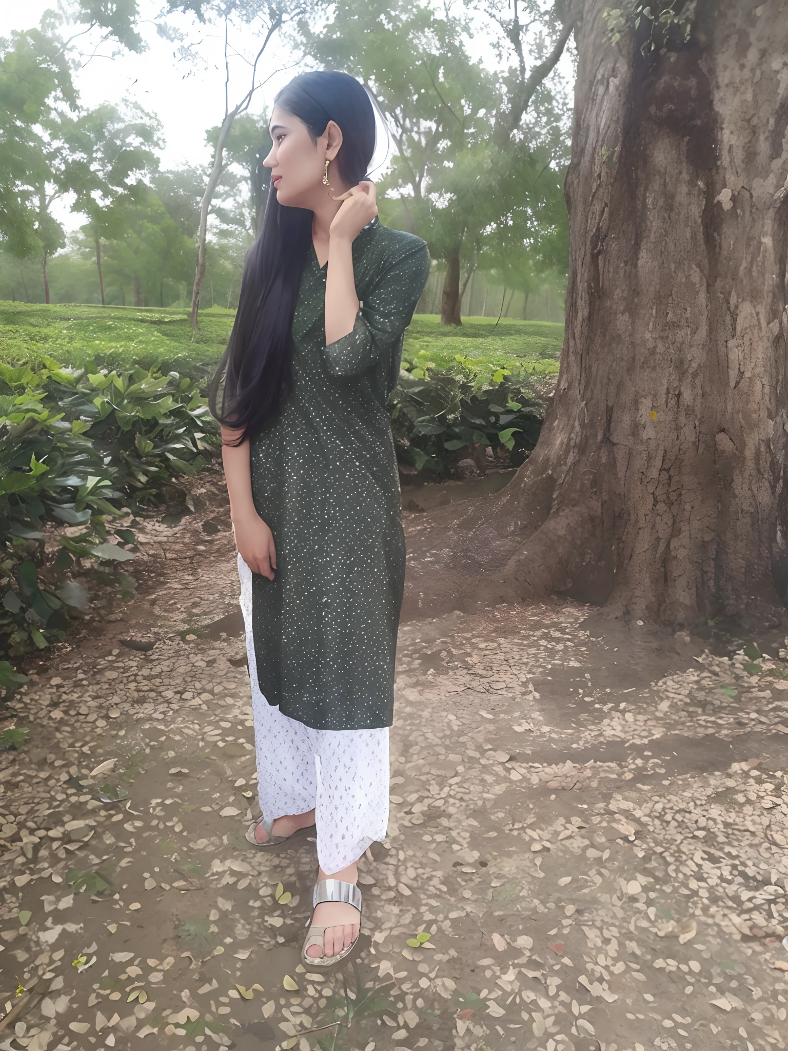 there is a woman standing in front of a tree talking on a cell phone, assamese aesthetic, wearing a kurta, wearing a silk kurta, wearing an elegant tribal outfit, green tunic, inspired by Puru, distant full body view, assamese, * colour splash *, desi, indian style, traditional beauty, standing gracefully upon a lotus