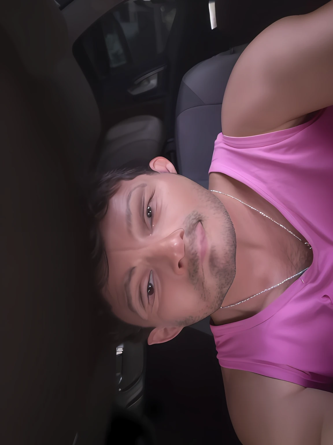 There's a man in a pink shirt sitting in a car, Homem de 4 0 anos, 38 anos, (38 anos), 3 6 anos, cerca de 3 5 anos, Homens de 45 anos, ele tem cerca de 4 0 anos de idade, ele tem cerca de 60 anos, ele tem cerca de 6 0 anos de idade