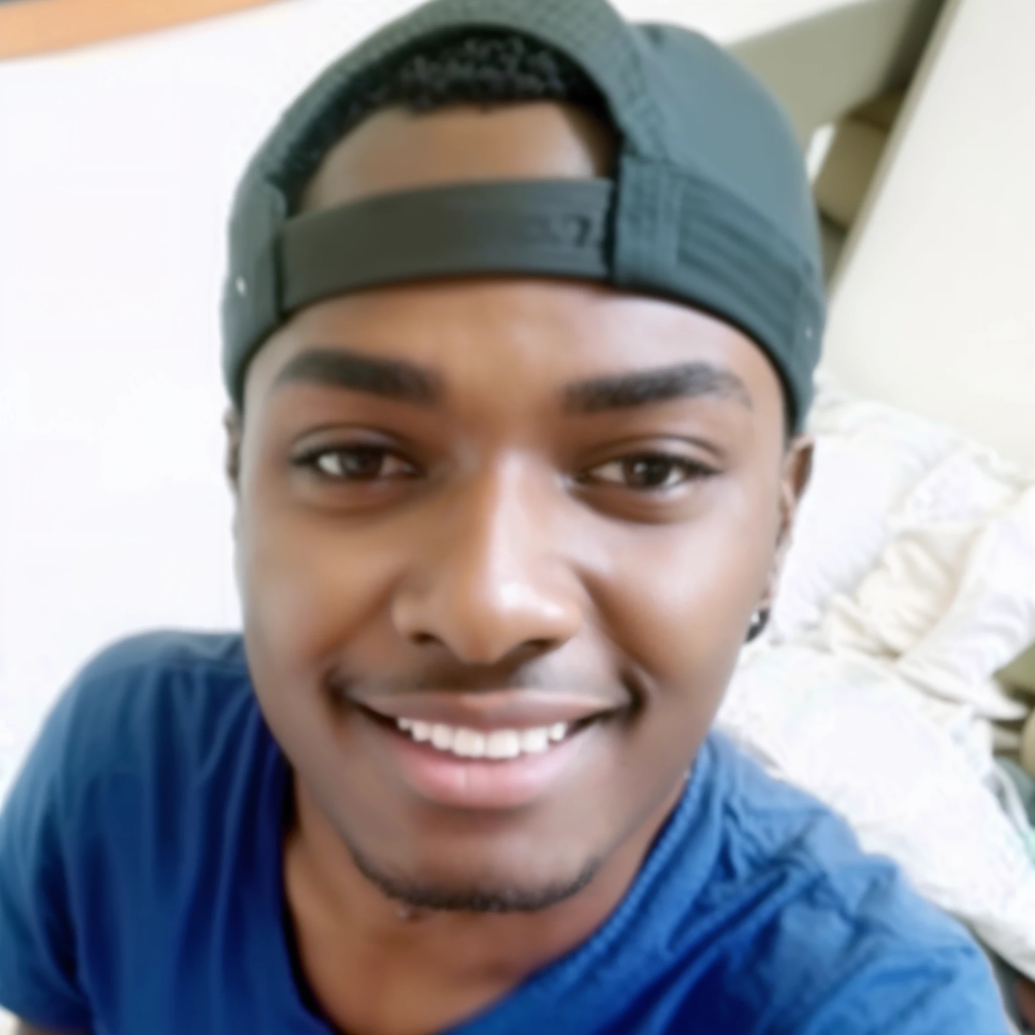 Smiling man in blue shirt and black hat sitting on the bed, Riyahd Cassiem, Mkbhd, Astor Alexande, raiado, foto do instagram, David Uzochukwu, Africano Canadense, adolescente ?????, Arik Roper, em torno de 1 9 anos, Atef, Jayison Devadas
