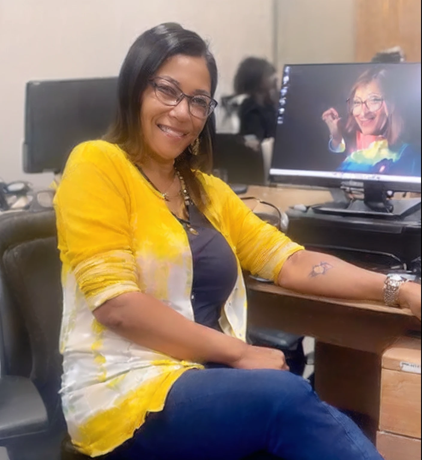 (Prompt A: smiling woman in her 50s with glasses:1.5), (Prompt B: wearing a yellow blouse and jeans:1.2), (Prompt C: sitting in a chair in the office:1.2)
