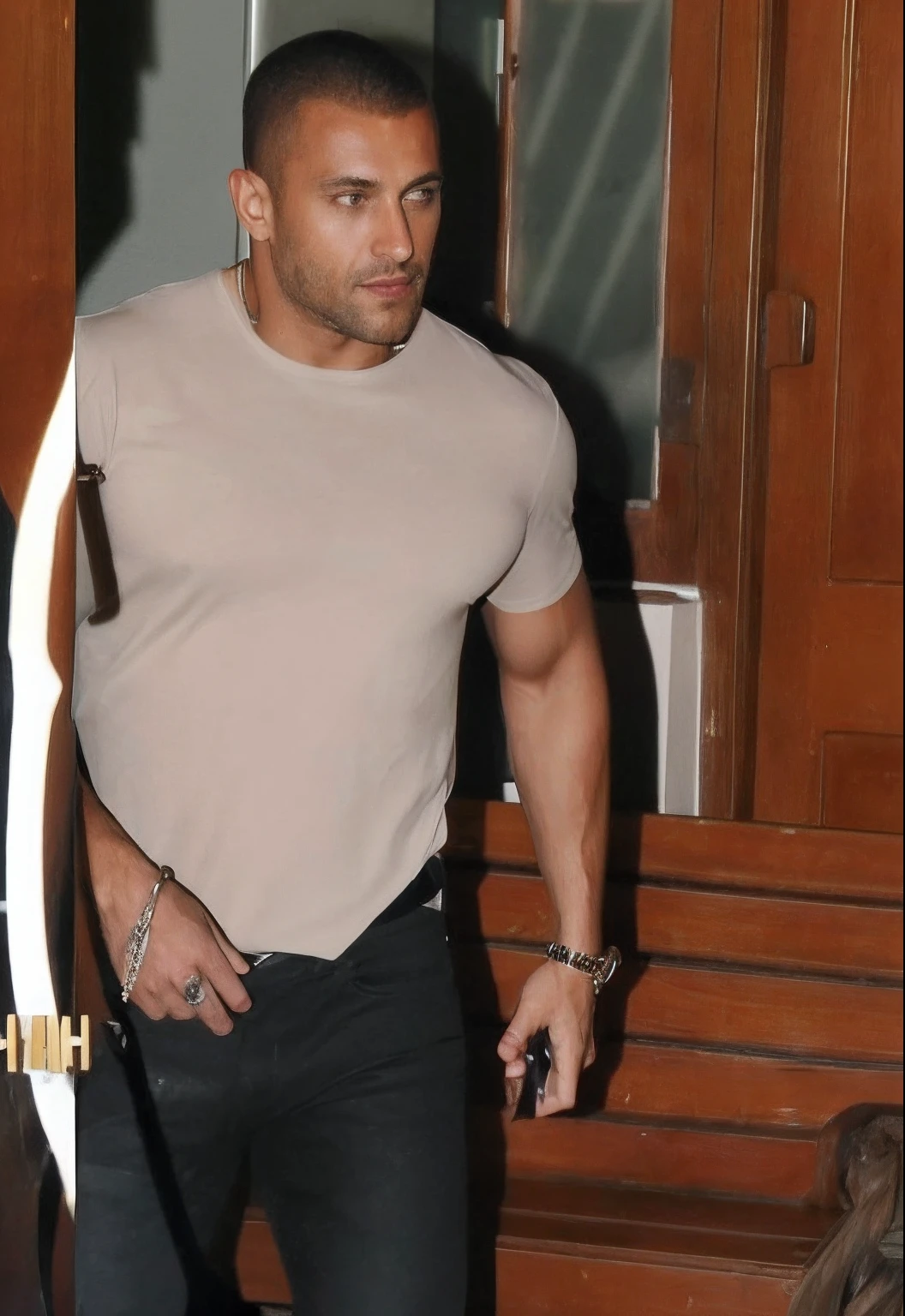 araffed man in a tan shirt and black jeans holding a white surfboard, he is wearing a black t-shirt, candid shot, in tshirt, mid-shot of a hunky, exclusive, menacing look, candid, usa-sep 20, tshirt, tight shirt, taken in the early 2020s, candid photo