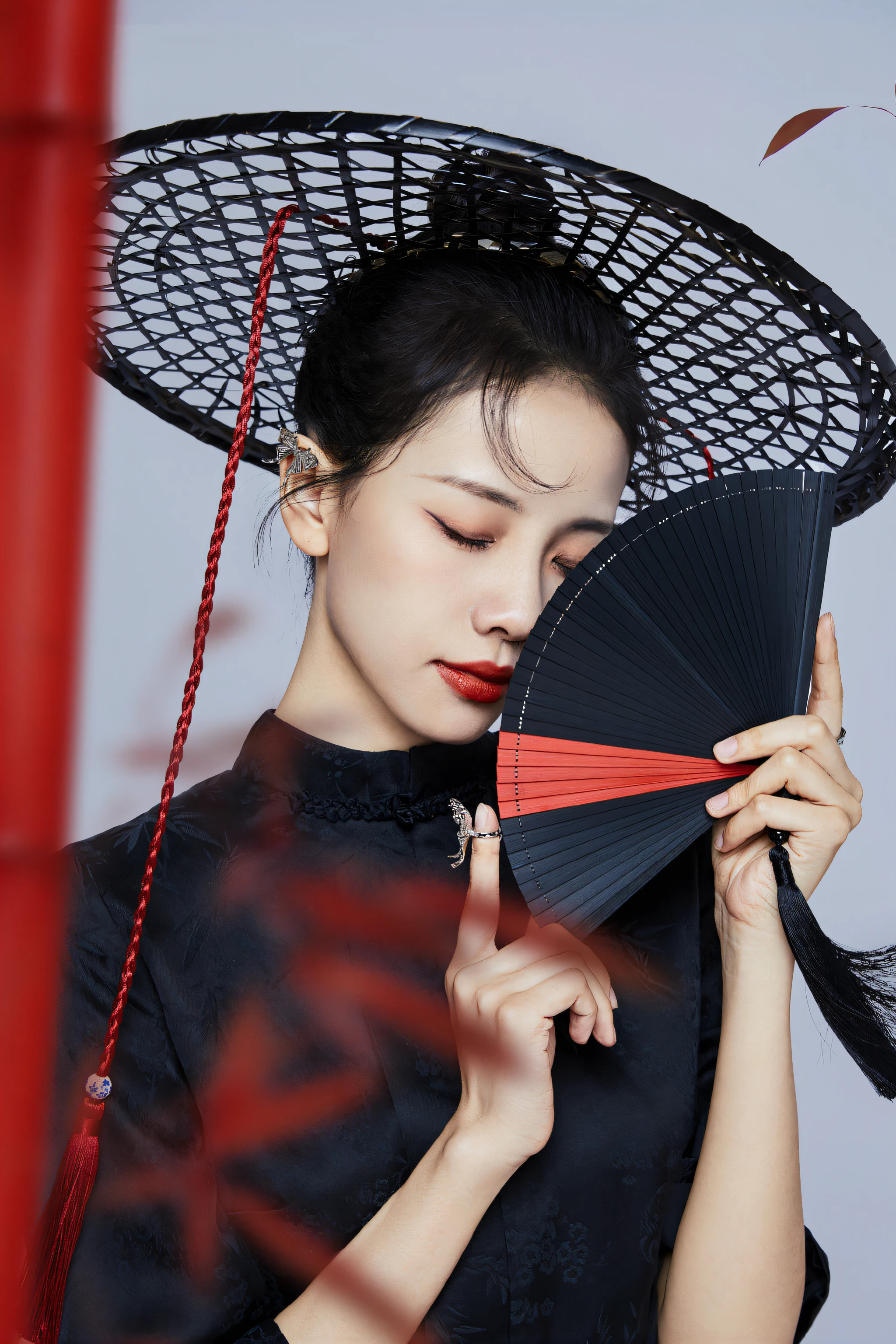 An Araki woman in a black dress holds a fan and a red pole, with acient chinese clothes, Hanfu, palace，Live-action texture，A girl in Hanfu, Chinese style, Chinese traditional, Chinese woman, black and red silk clothing, Japanese model, on cheongsam, Traditional Chinese clothing, Traditional beauty, Chinese girl, inspired by Fan Qi, inspired by Gong Xian