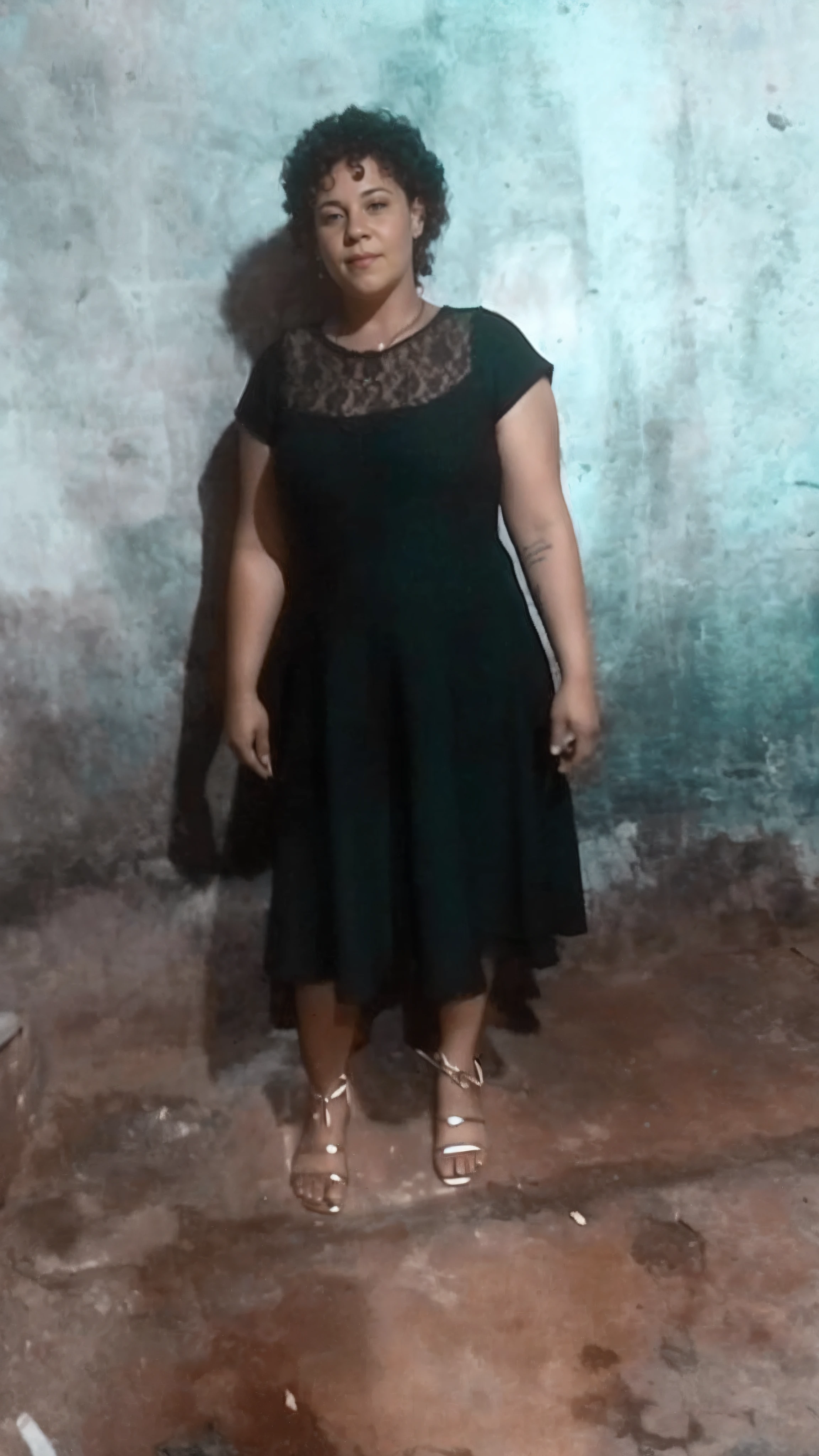 There is a woman standing in a room with a wall painted blue, imagem de corpo inteiro, background is celestial, ela usa um vestido verde escuro, she is wearing a black dress, Mulher de 30 anos, 3 0 anos de idade mulher, Fotografia tirada em 2 0 2 0, ela tem cerca de 2 0 anos, ela tem cerca de 20 anos