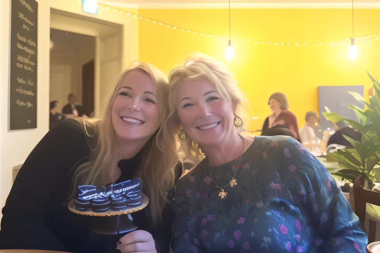there are two women sitting at a table with a cake, non blurry, not blurry, both smiling for the camera, beautiful lady, beautiful surroundings, slightly blurred, taken on a 2010s camera, both laughing, having a great time, by Else Alfelt, taken in the early 2020s, photo taken in 2 0 2 0