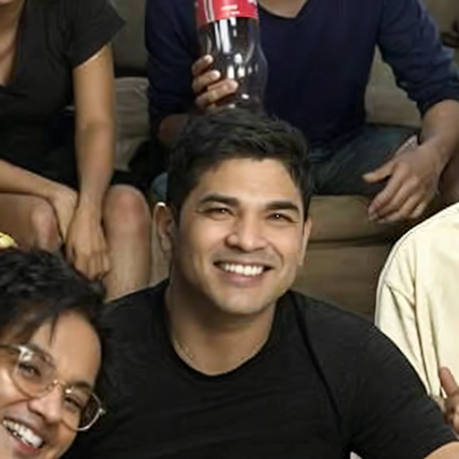 Smiling group of people sitting on a couch with a bottle of soda, taken in the early 2020s, foto do perfil, taken in the late 2010s, muito ligeiramente sorridente, tiradas no final dos anos 2000, david rios ferreira, foto de perfil, ligeiramente sorridente, José Moncada, candid shot, he's smiling