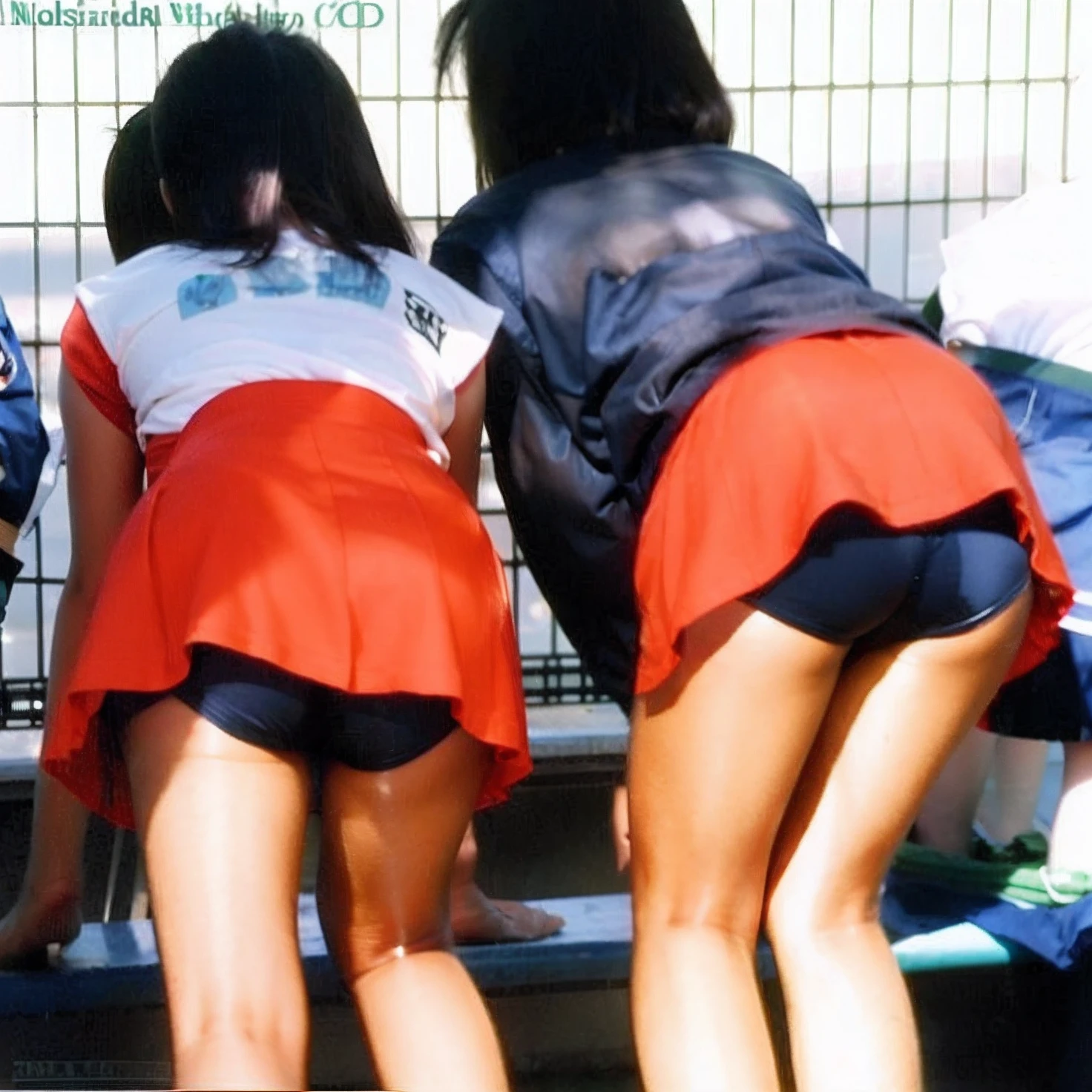 Two women in red skirts are standing next to the fence, two japanese schoolgirls posing, Japan school uniform, wearing japanese school uniform, a miniskirt, japanese girl school uniform, 80's japanese photo, Miniskirt, 90s japan, rumiko, Bending over, ikki tousen, bum, Short miniskirt, of a schoolgirl posing、Wearing spandex shorts、8K、fascinating butt