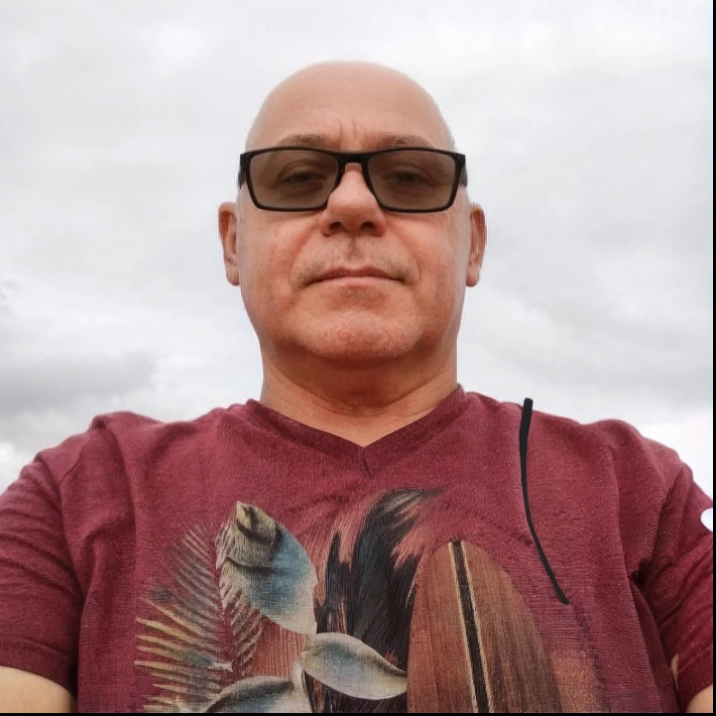 Man in red shirt and sunglasses sitting on a beach, foto de um homem branco de 50 anos, taken in the early 2020s, cerca de 3 5 anos, Fotografia tirada em 2 0 2 0, foto de perfil, fotografia tirada em 2 0 2 0, Fotografia Realisitc, foto de perfil, album photo, foto retrato